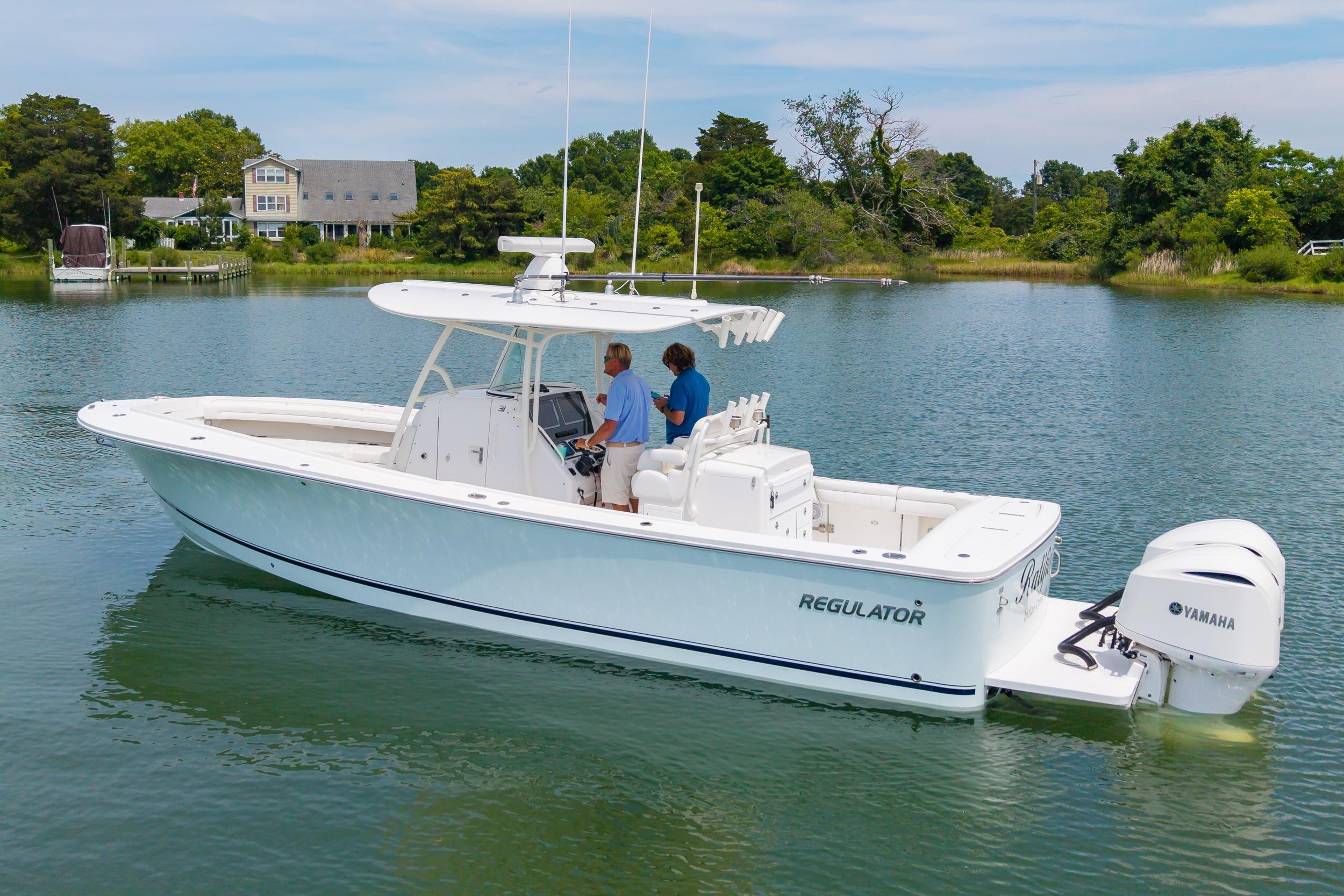 2019 Regulator 31 boat on calm water with Yamaha engines, surrounded by lush greenery.