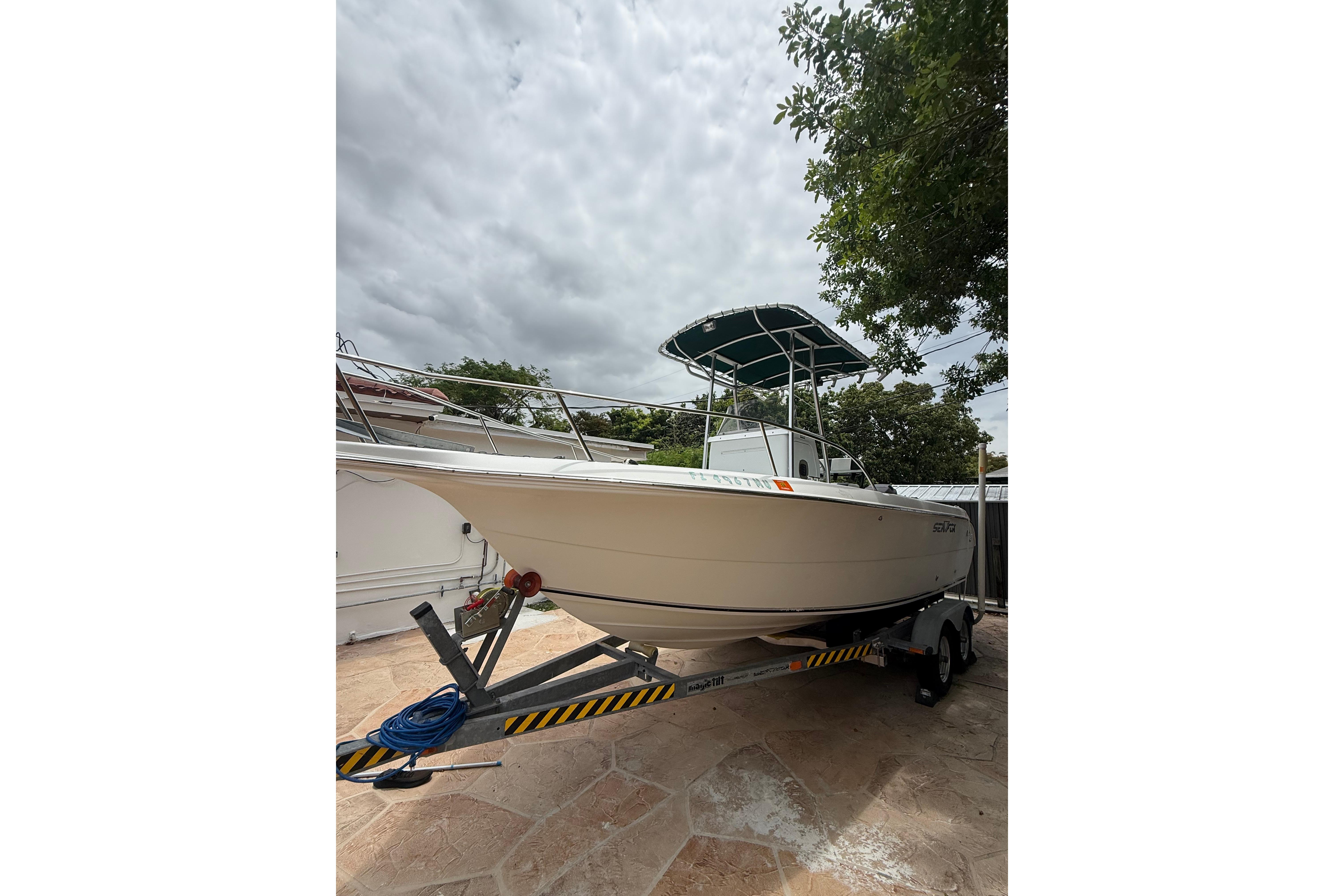 2005 LYG Sea Fox boat on trailer, parked outdoors under cloudy sky.