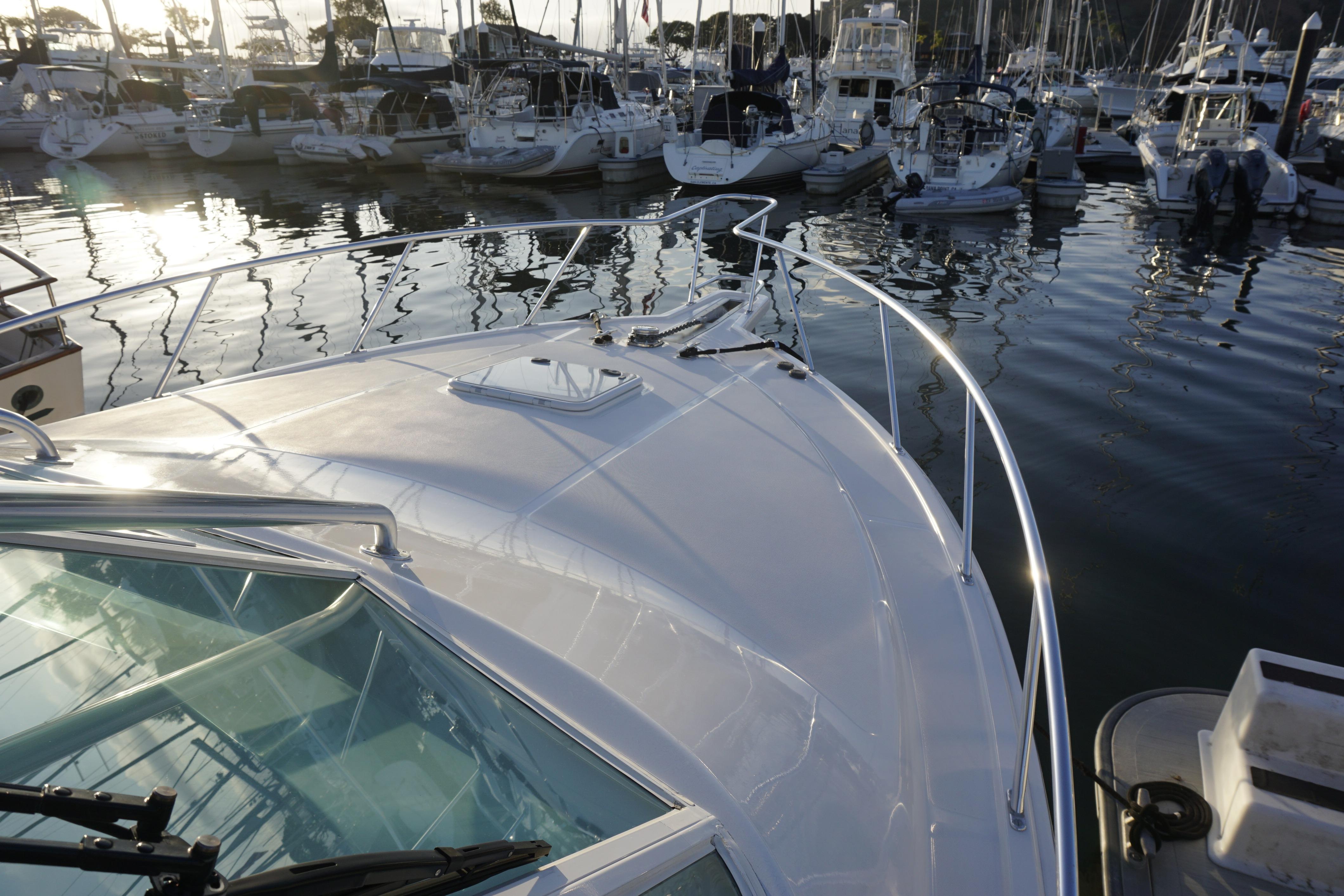 2005 Cabo 35 Express yacht docked in a marina, surrounded by other boats.