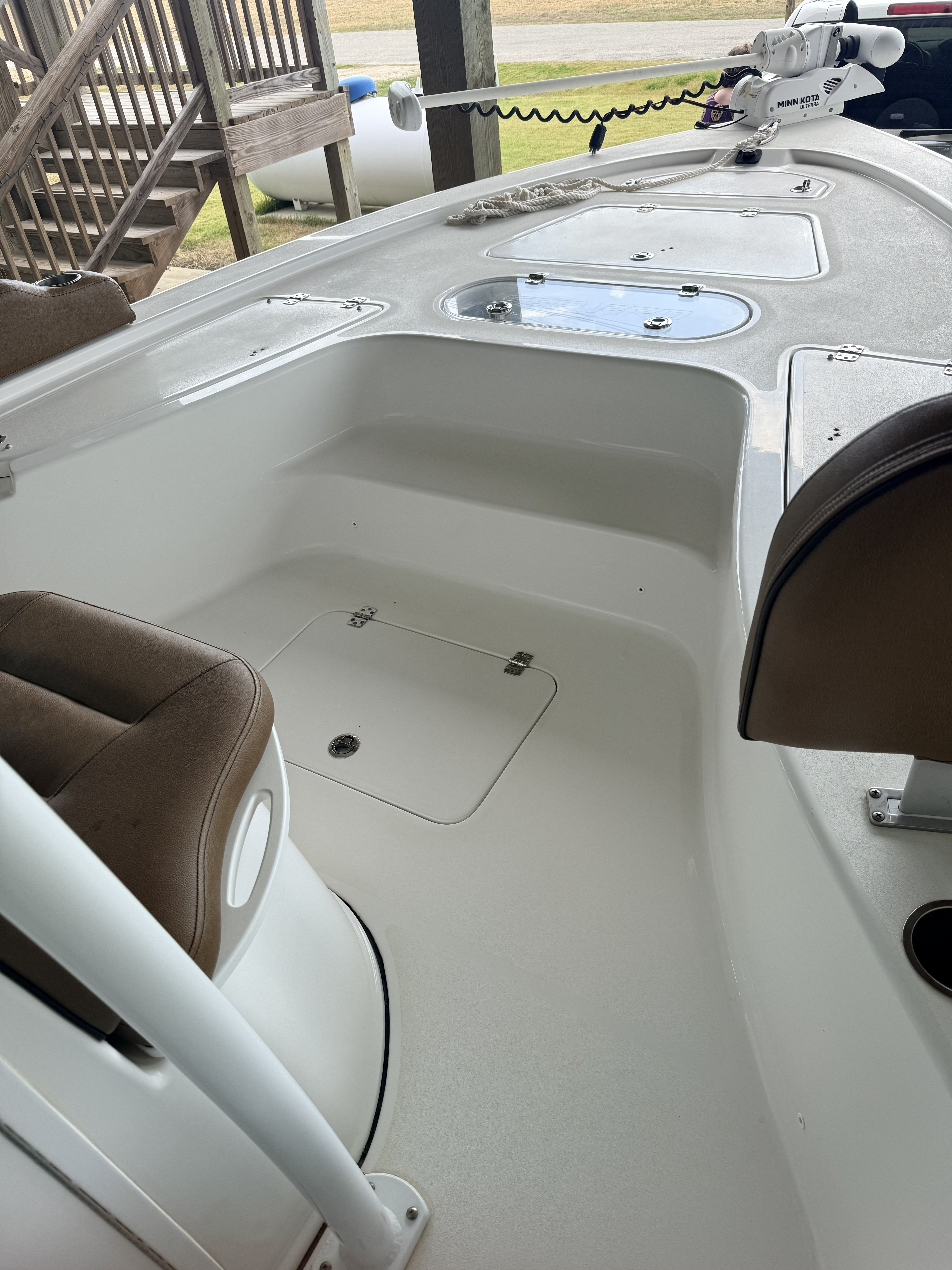 A Sea Pro 248 Bay boat with white seating and a helm station.