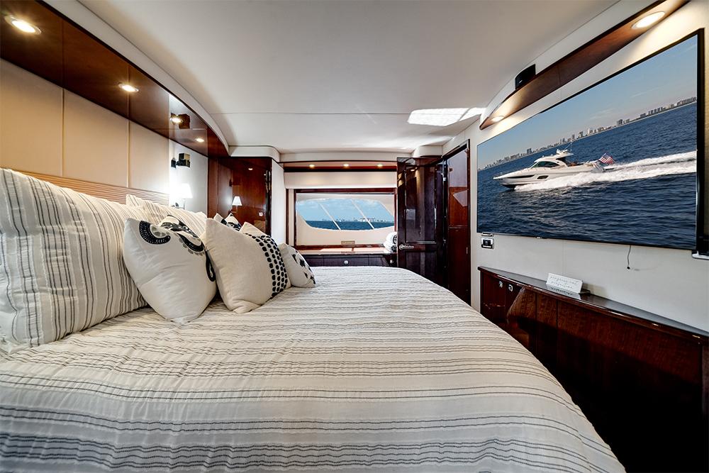 Luxurious interior of 2012 Sea Ray 610 Sundancer yacht with elegant bedroom and large window view.