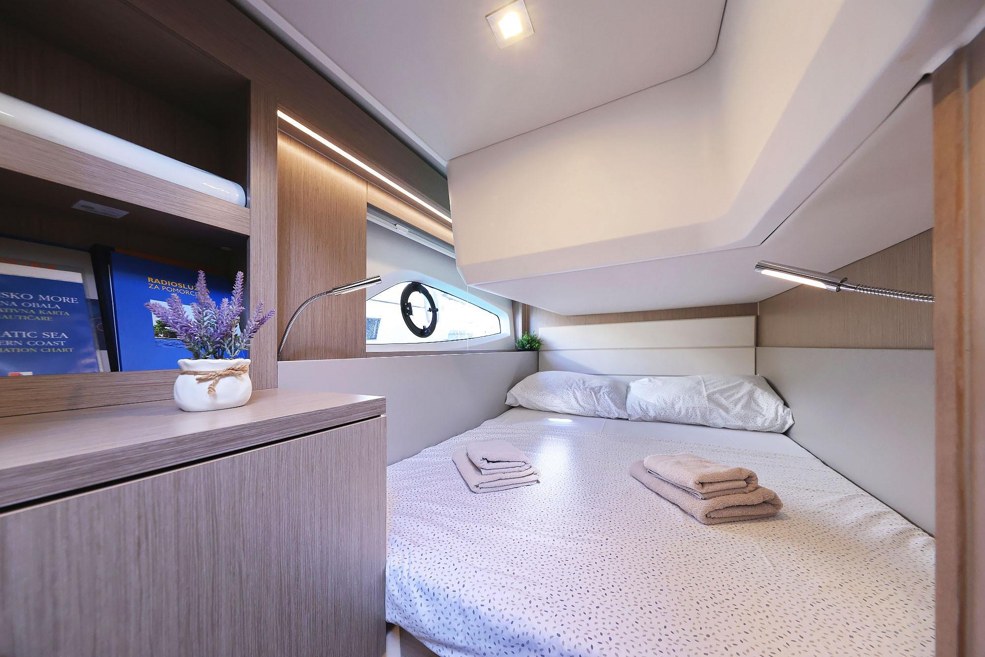 Luxurious cabin interior of 2024 Sealine C390 yacht with cozy bedding and elegant decor.