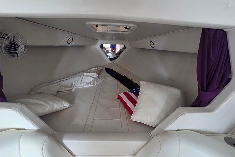 Interior cabin of a 2004 Fountain 38 Lightning boat with bedding and fan.