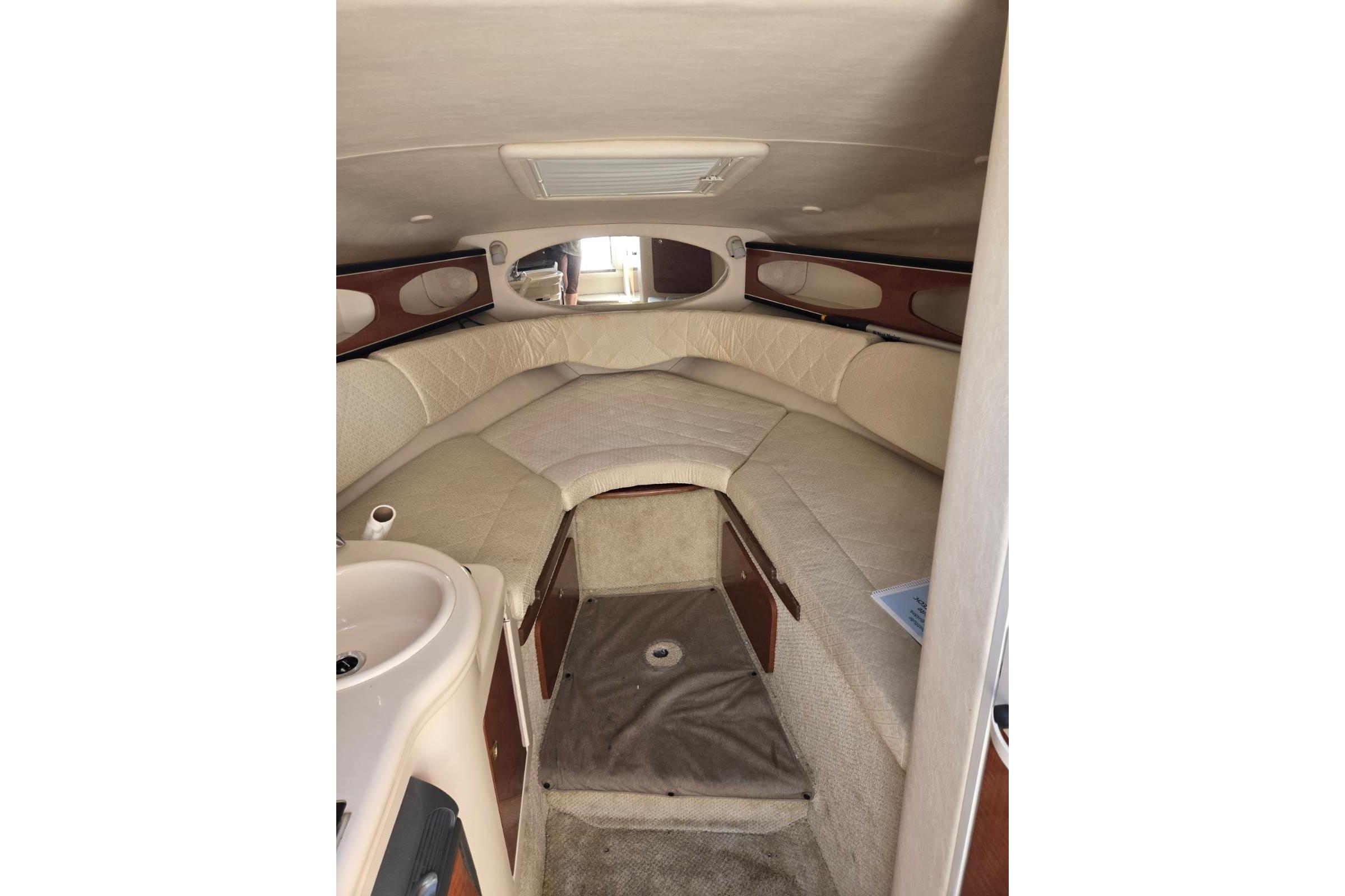 Interior cabin of 2004 Sea Ray Sundancer 260, featuring cozy seating and compact sink.