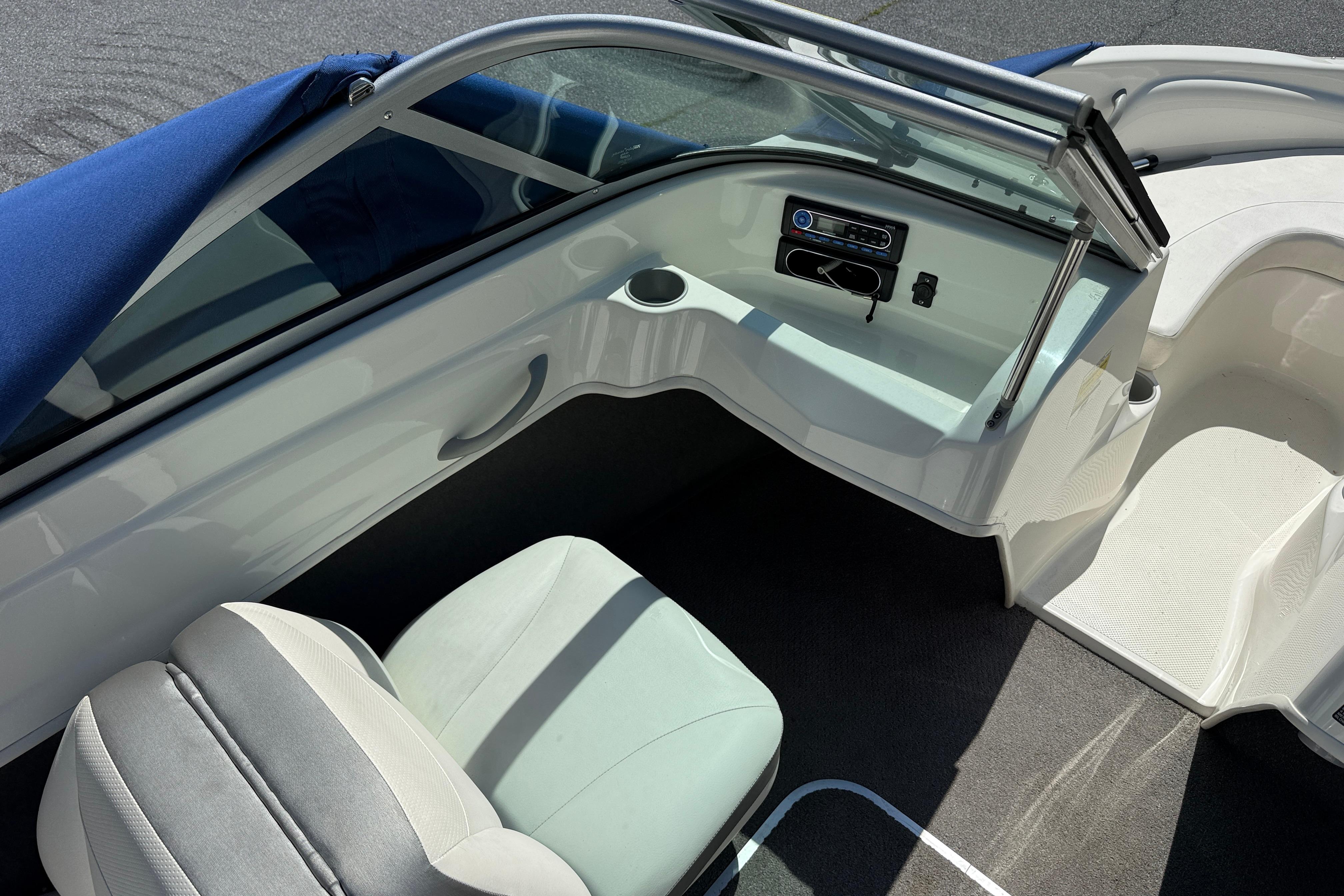 2009 Bayliner 175 boat interior with seating, dashboard, and blue cover.