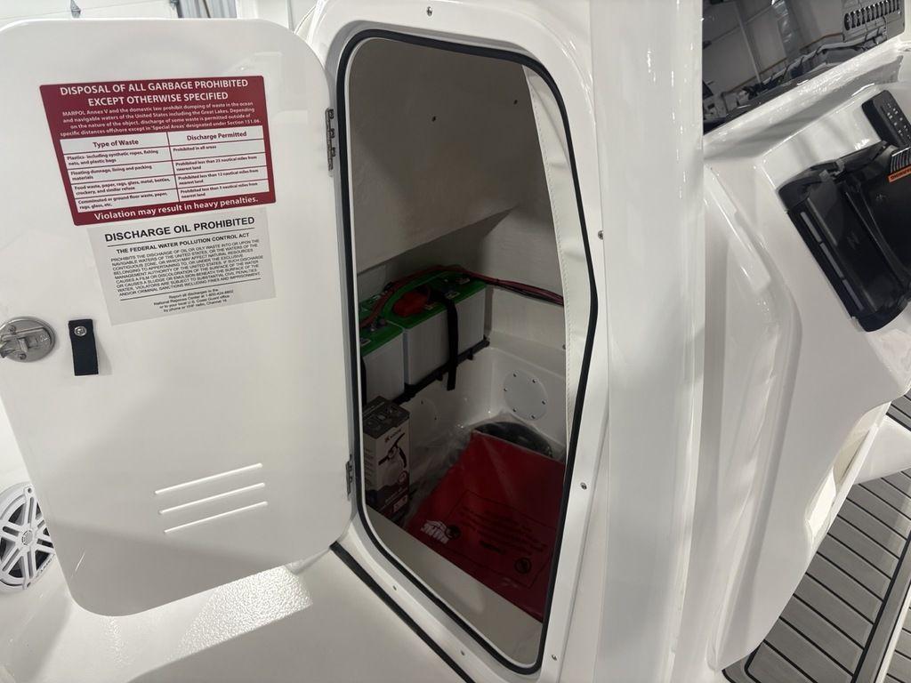 Open storage compartment on 2026 Tidewater 2110 BM boat, showing interior and safety instructions.