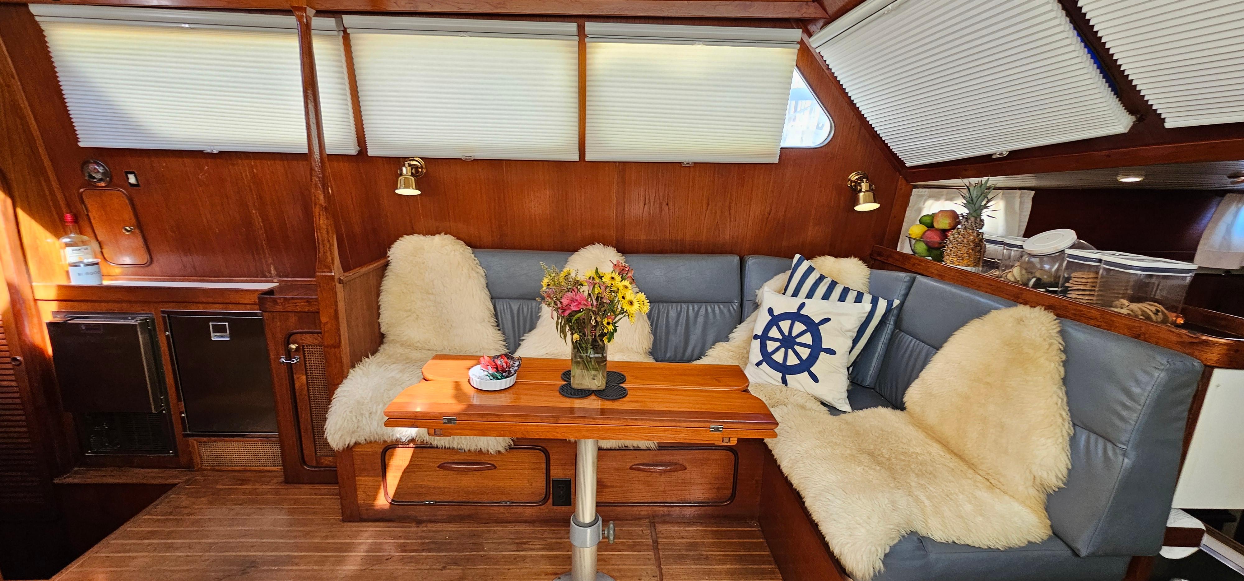 Cozy interior of 1980 Gulfstar 47 Sailmaster with plush seating and nautical decor.