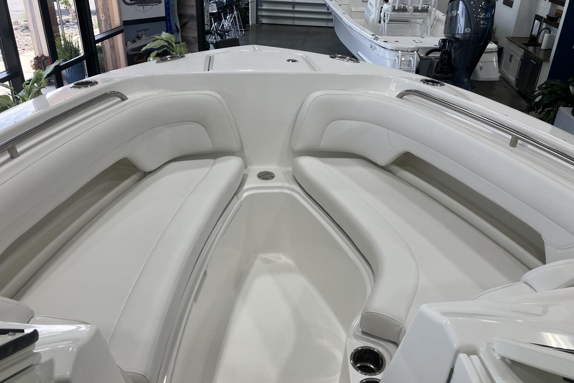 2026 Albemarle 27 Dual Console boat interior with white cushioned seating in showroom.