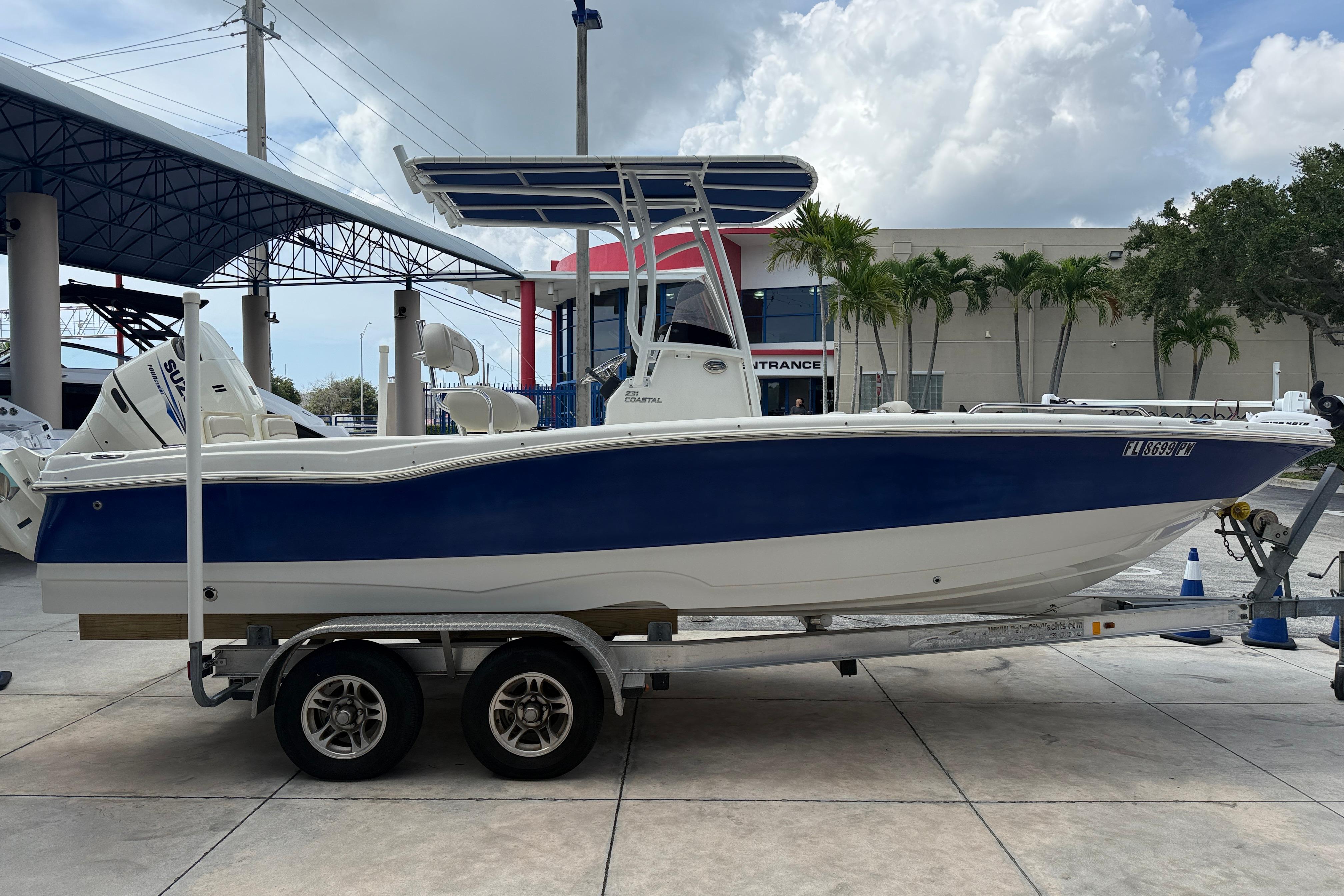 2015 NauticStar 231 Coastal boat on trailer, blue and white design, outdoor setting.