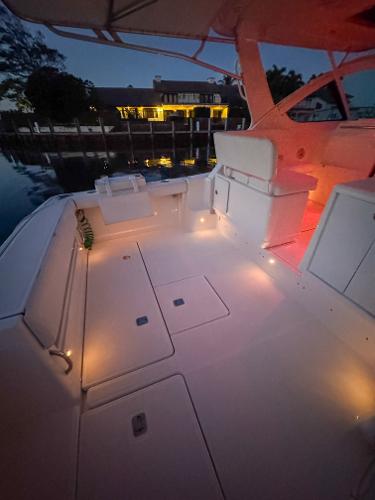 2006 Tiara Yachts 3200 Open boat deck illuminated at dusk, docked near waterfront home.