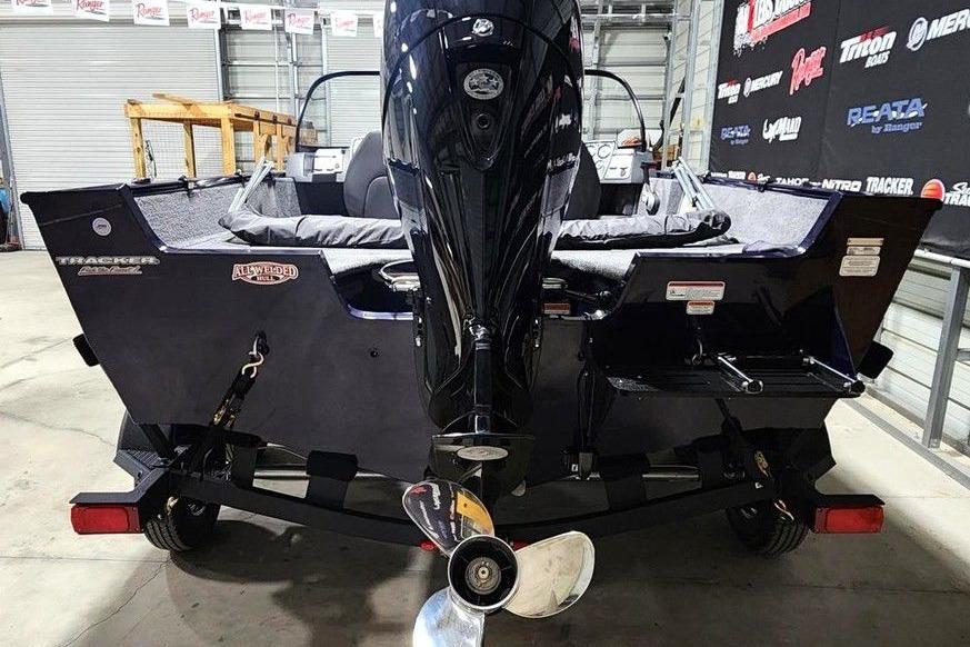 2026 Tracker Pro Guide V-175 Combo boat in showroom, rear view with motor and trailer.