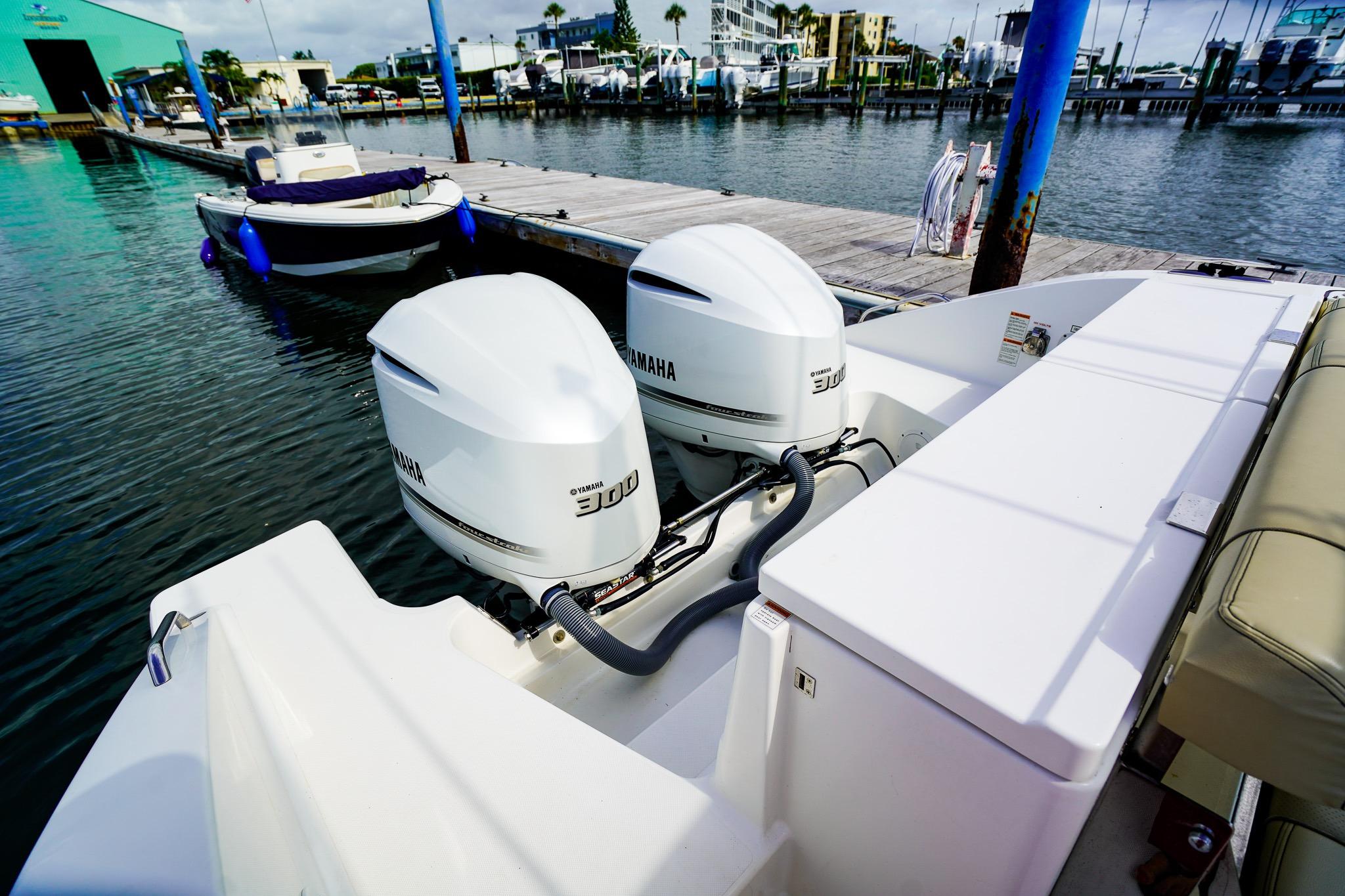 2020 Pursuit OS 325 Offshore boat with twin Yamaha 300 engines docked at marina.