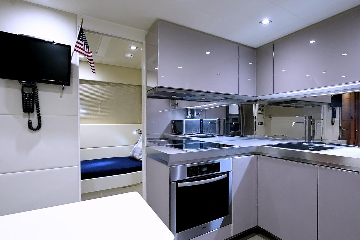 Modern kitchen interior on 2015 Pershing 92 yacht, featuring sleek cabinetry and appliances.