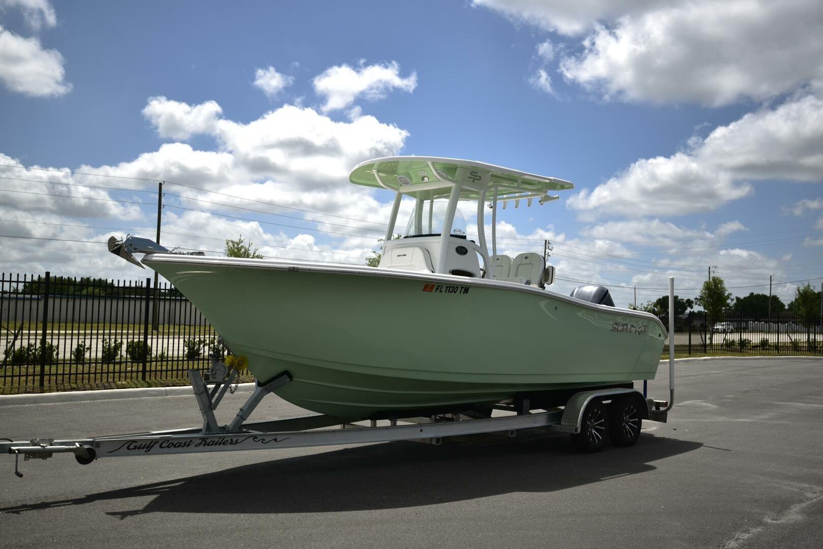 2023 Sea Pro 239 Deep V CC boat on trailer under a cloudy sky.