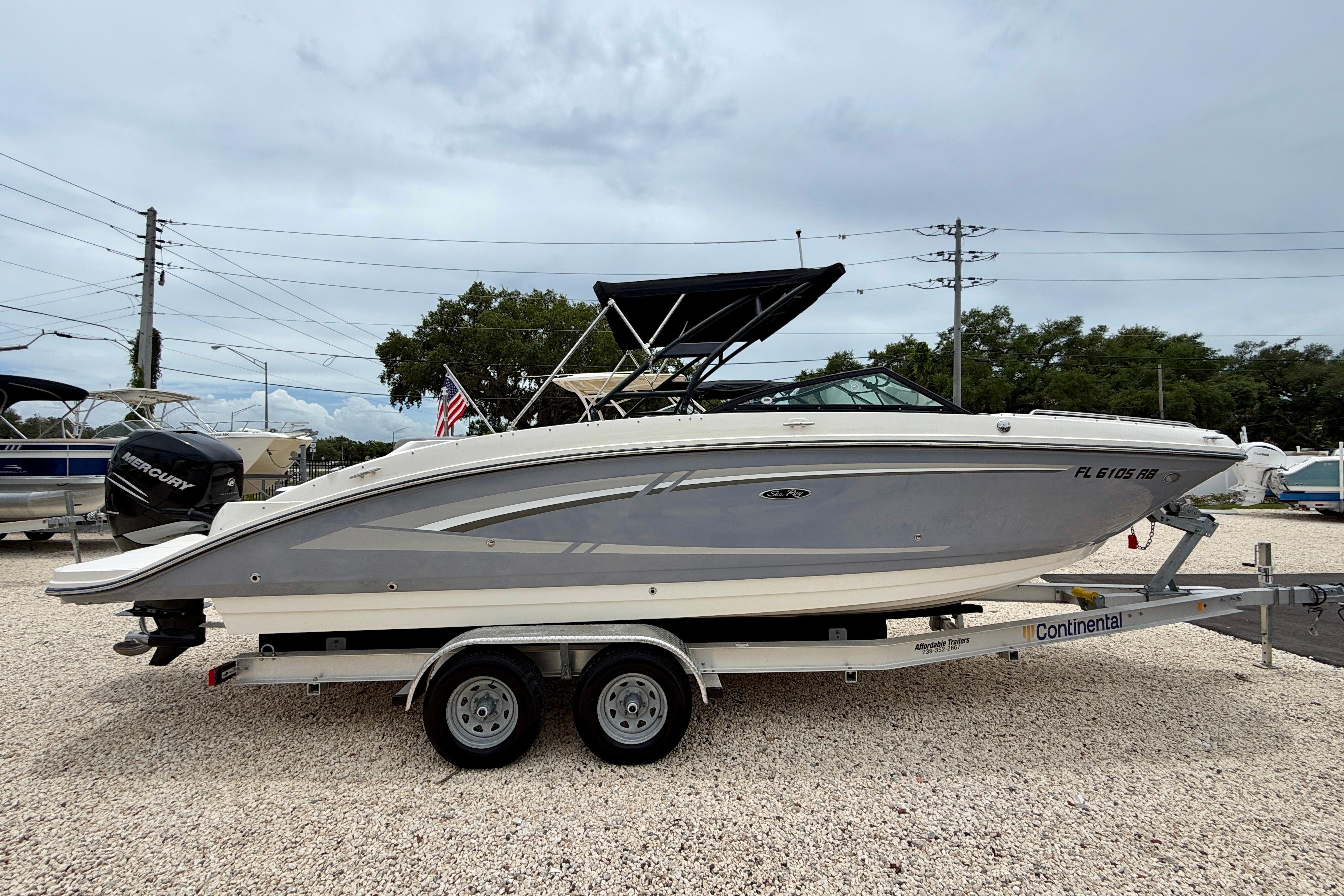 2016 Sea Ray 270 Sundeck Outboard on trailer, parked outdoors, side view.