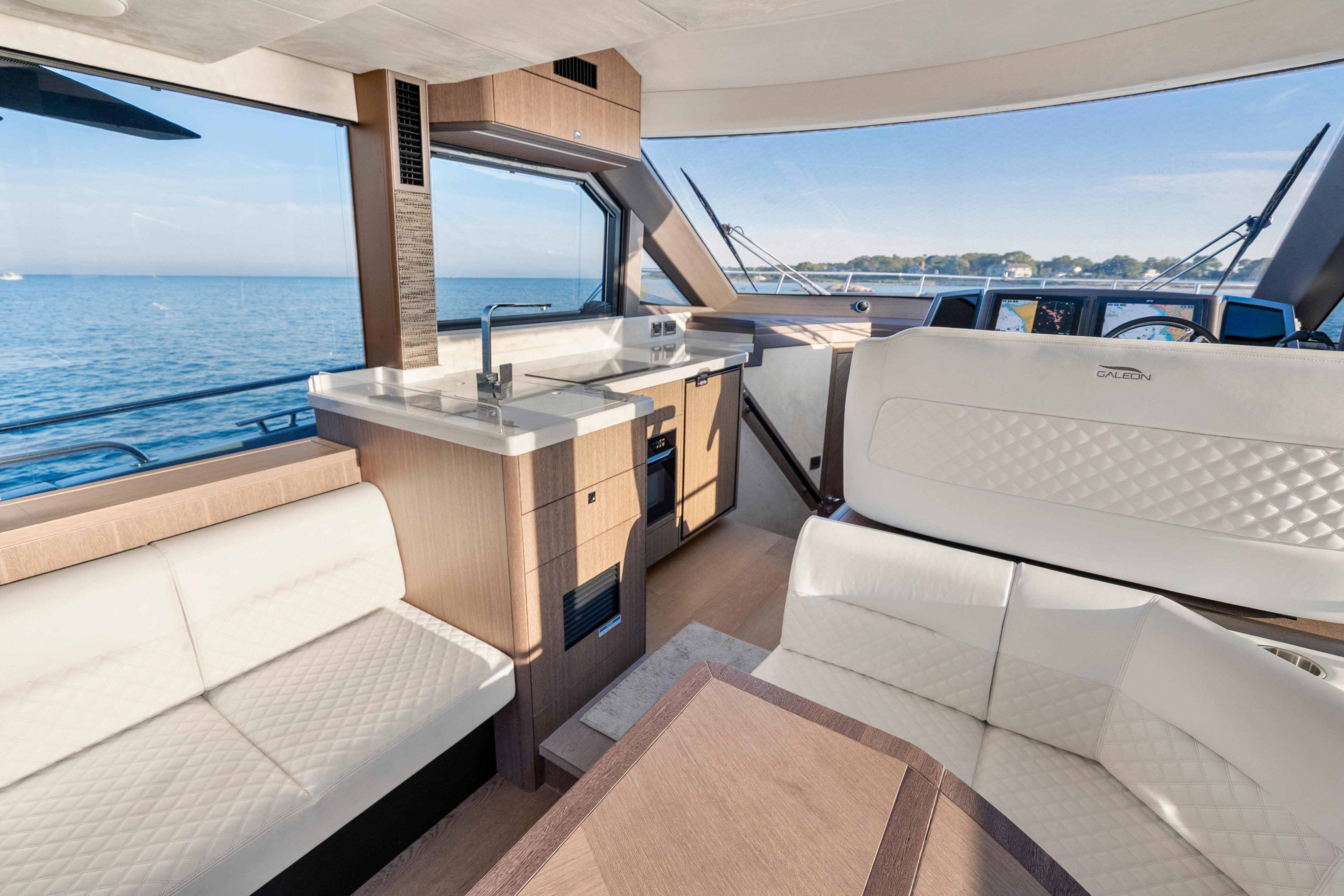 Luxurious interior of 2023 Galeon 400 Fly yacht with modern kitchen and seating area.