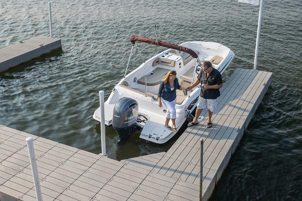 2025 Hurricane SunDeck Sport 205 OB docked with people boarding.