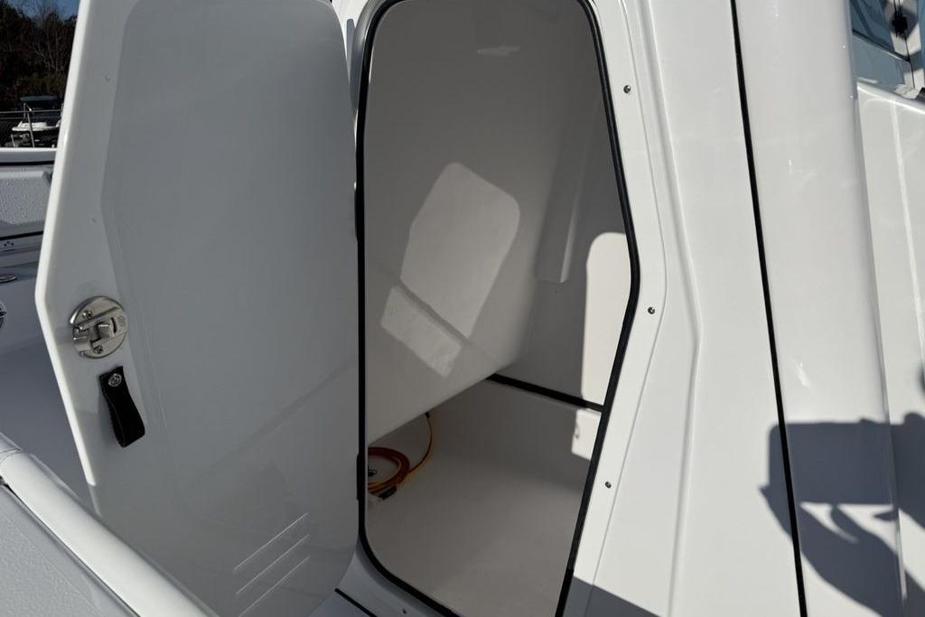 2026 Sportsman Masters 247OE Bay Boat interior storage compartment with open door.