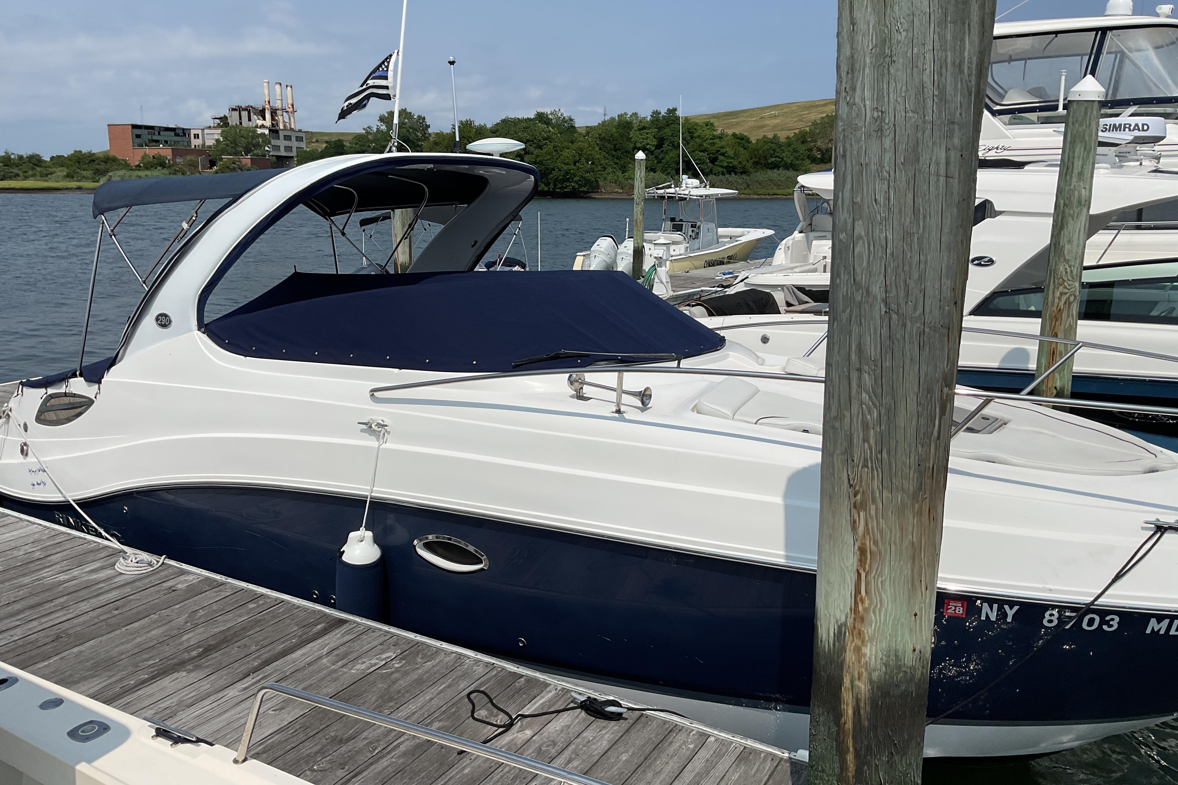 2013 Rinker 290 Express Cruiser docked at marina, covered and ready for use.