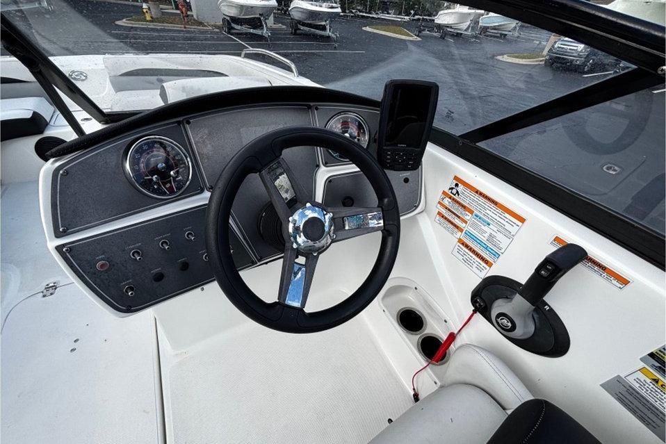 2022 Hurricane SunDeck 217 OB boat dashboard with steering wheel and control panel.
