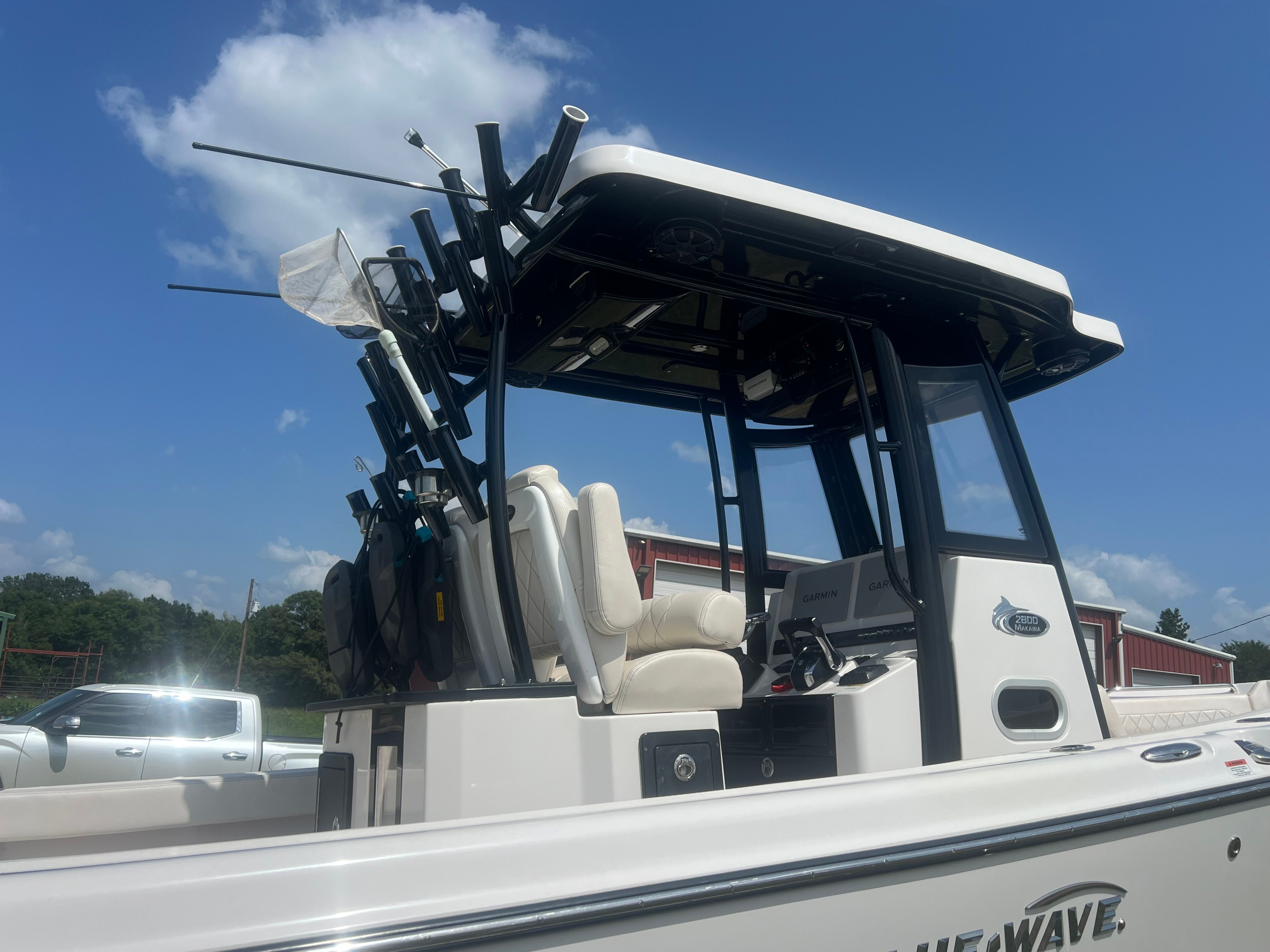 The image shows a 2023 Blue Wave 2800 Makaira boat with multiple fishing rod holders.