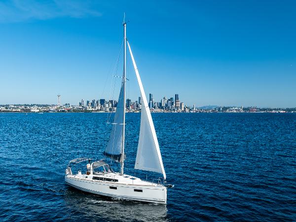 2021 Beneteau Oceanis 38.1 sailboat with city skyline backdrop.