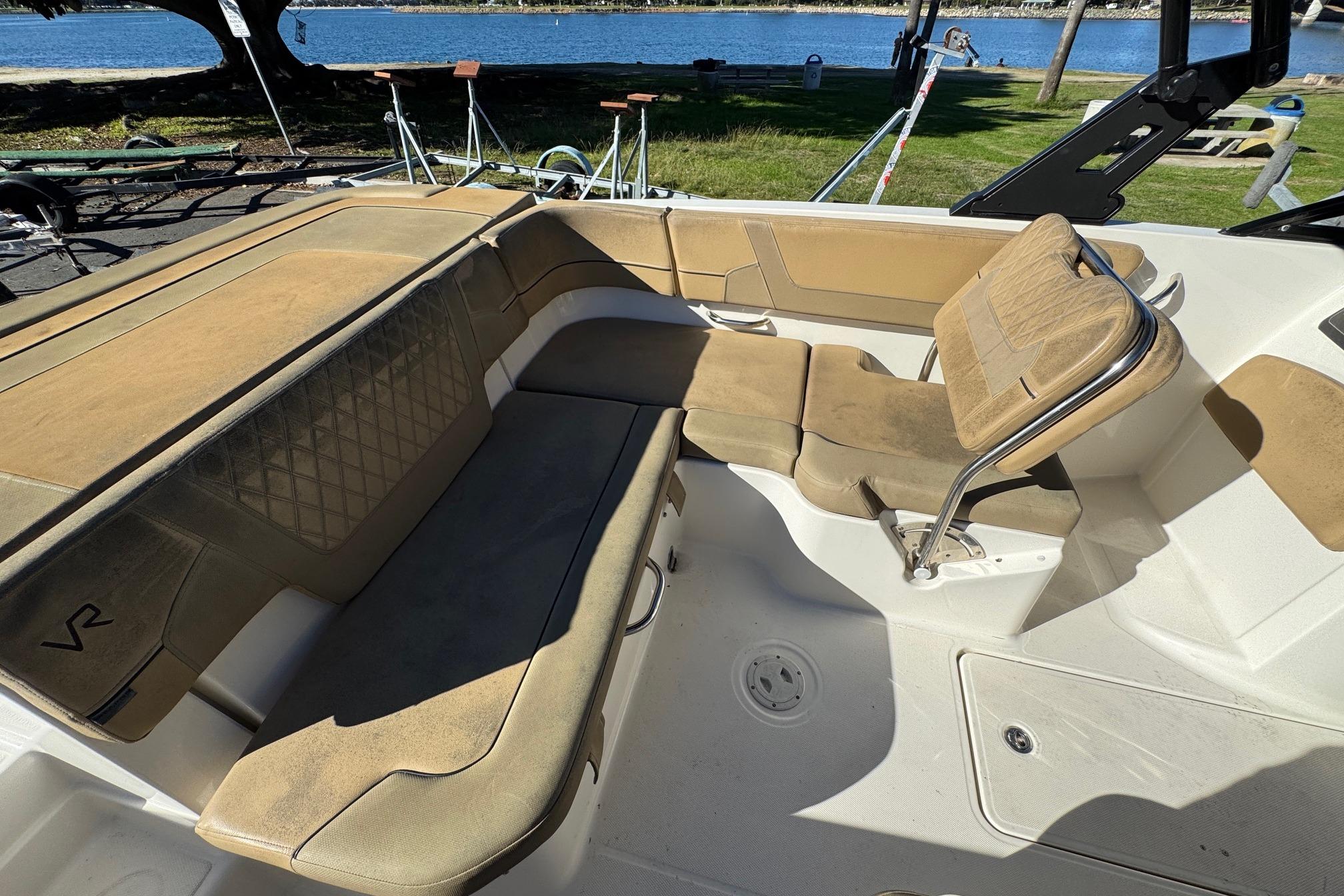 2022 Bayliner VR6 Bowrider OB interior with tan seating, near a waterfront setting.