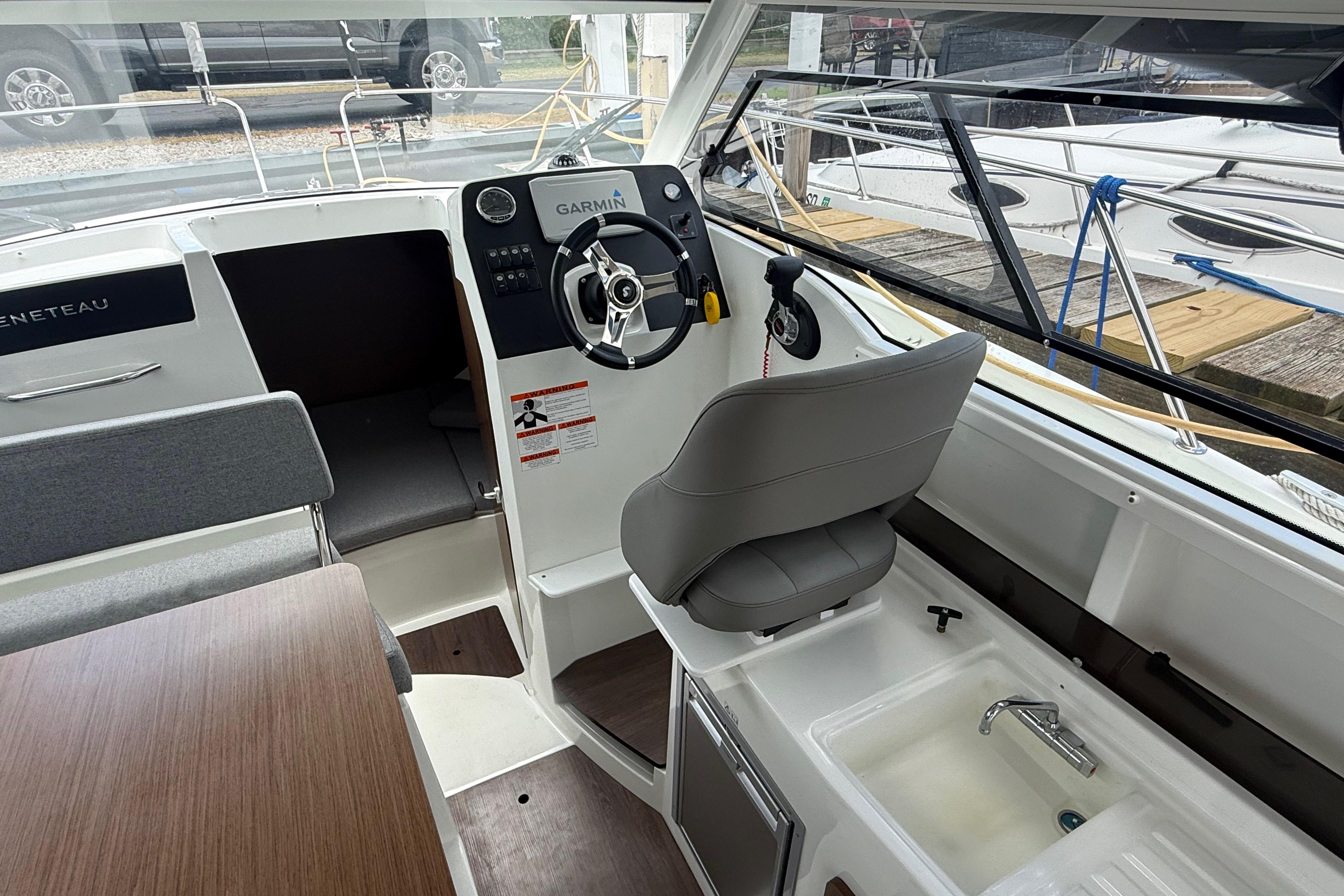 Interior of a 2019 Beneteau Antares 23 boat with steering wheel and seating.