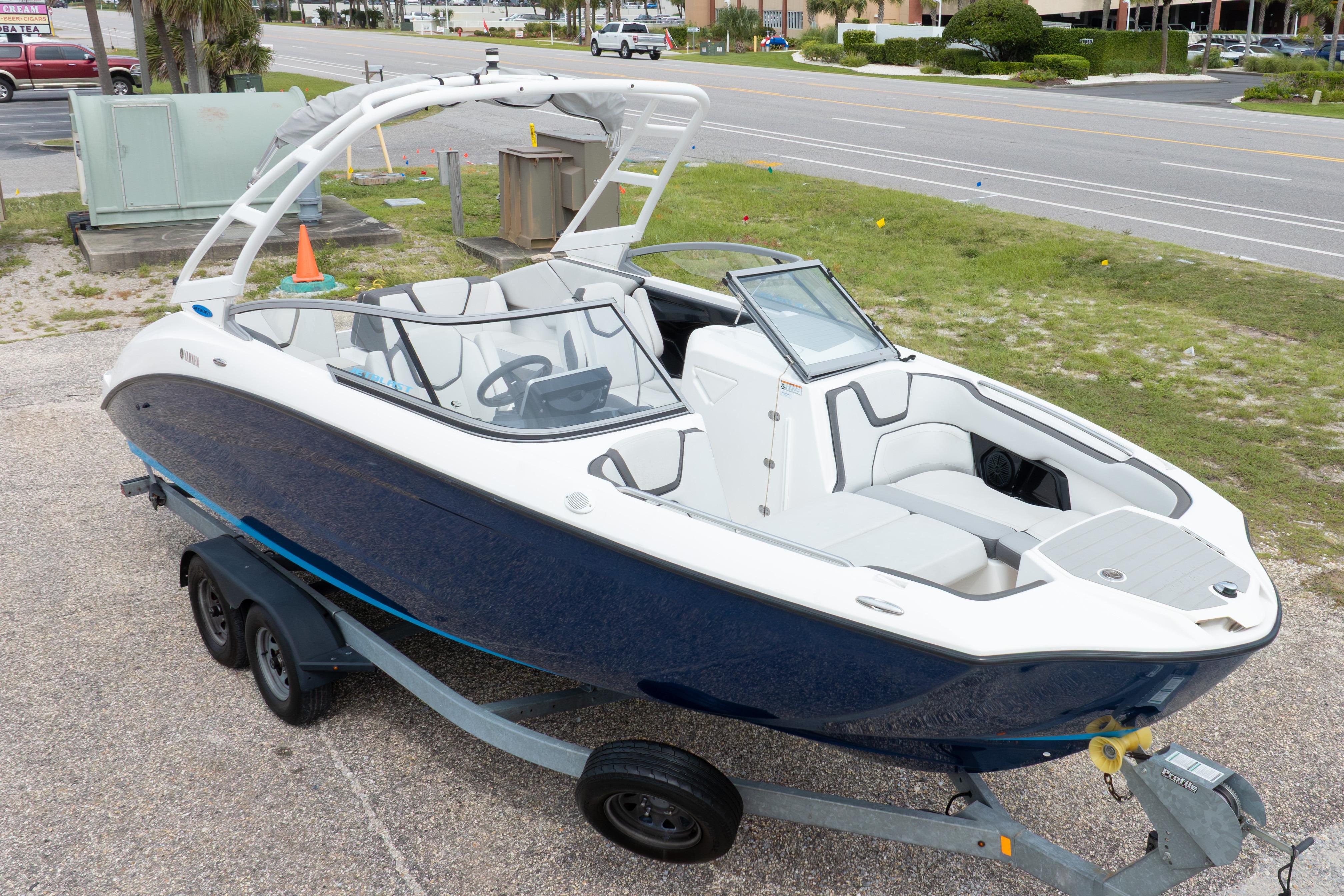 2021 Yamaha Boats AR250 on trailer, sleek design, white and blue exterior, parked roadside.