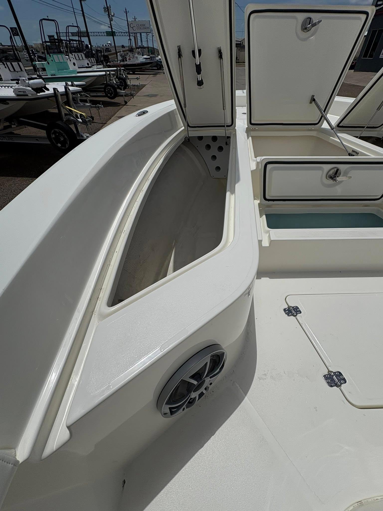 2025 Mako 24 APEX boat interior with open storage compartments and speaker.