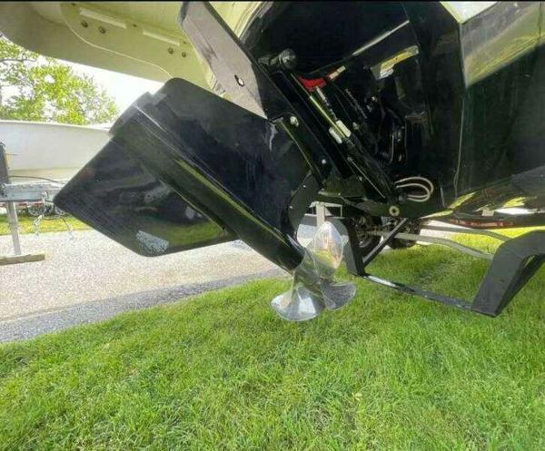 2022 Chaparral 23 Surf boat propeller and outdrive on grass.