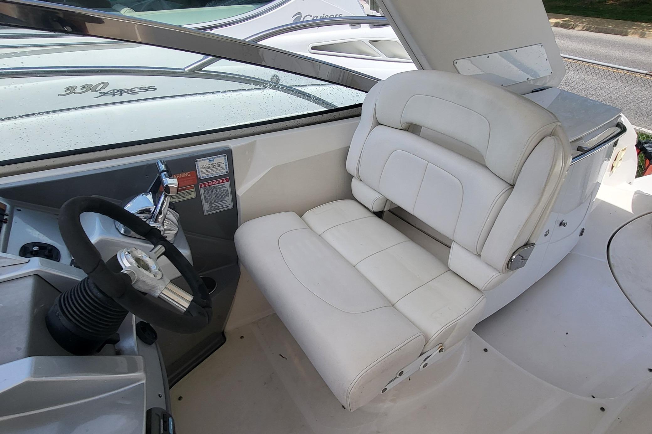 Captain's seat and helm of a 2008 Monterey 350 Sport Yacht, featuring white upholstery.