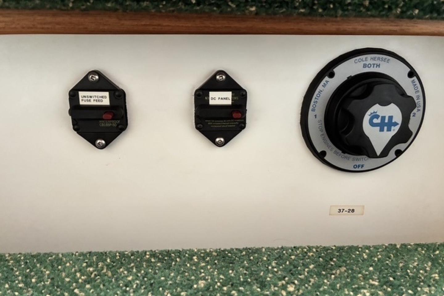 Control panel of a 2000 Nordic Tug 37 with switches and a rotary dial.