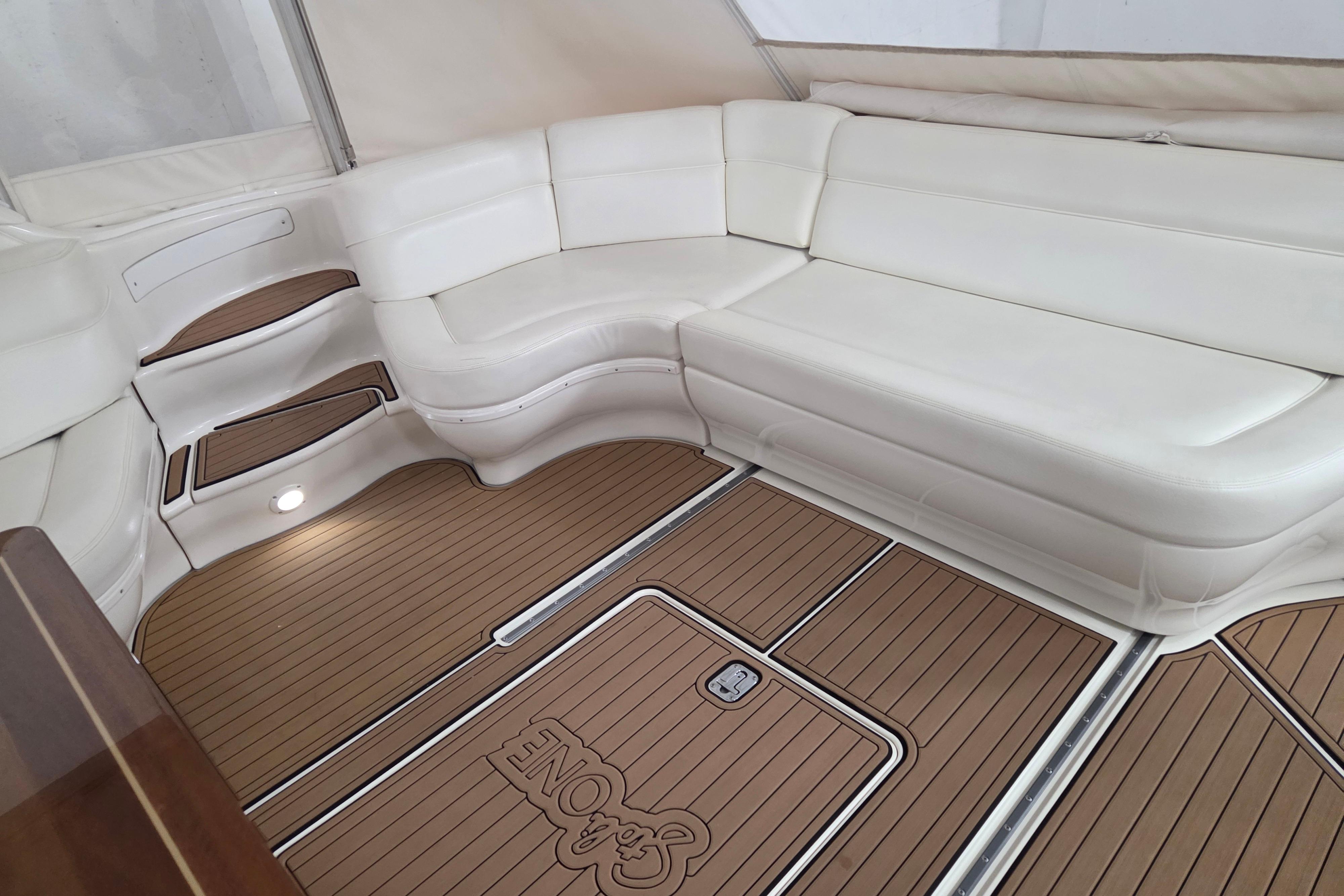 Luxurious interior of 2000 Sea Ray Sundancer 540 with white seating and teak flooring.