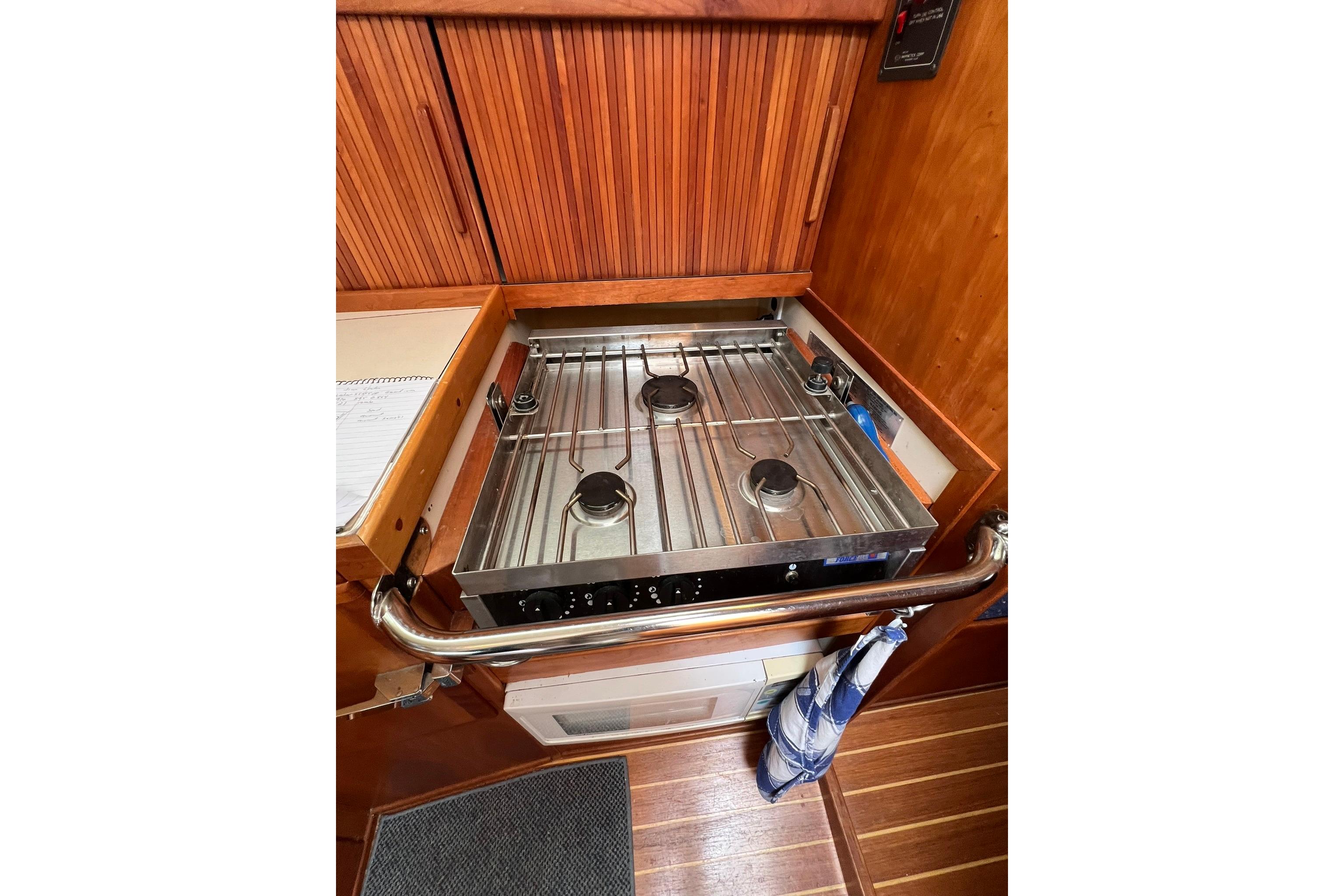 1998 Sabre 362 yacht kitchen with stainless steel stove and wooden cabinetry.