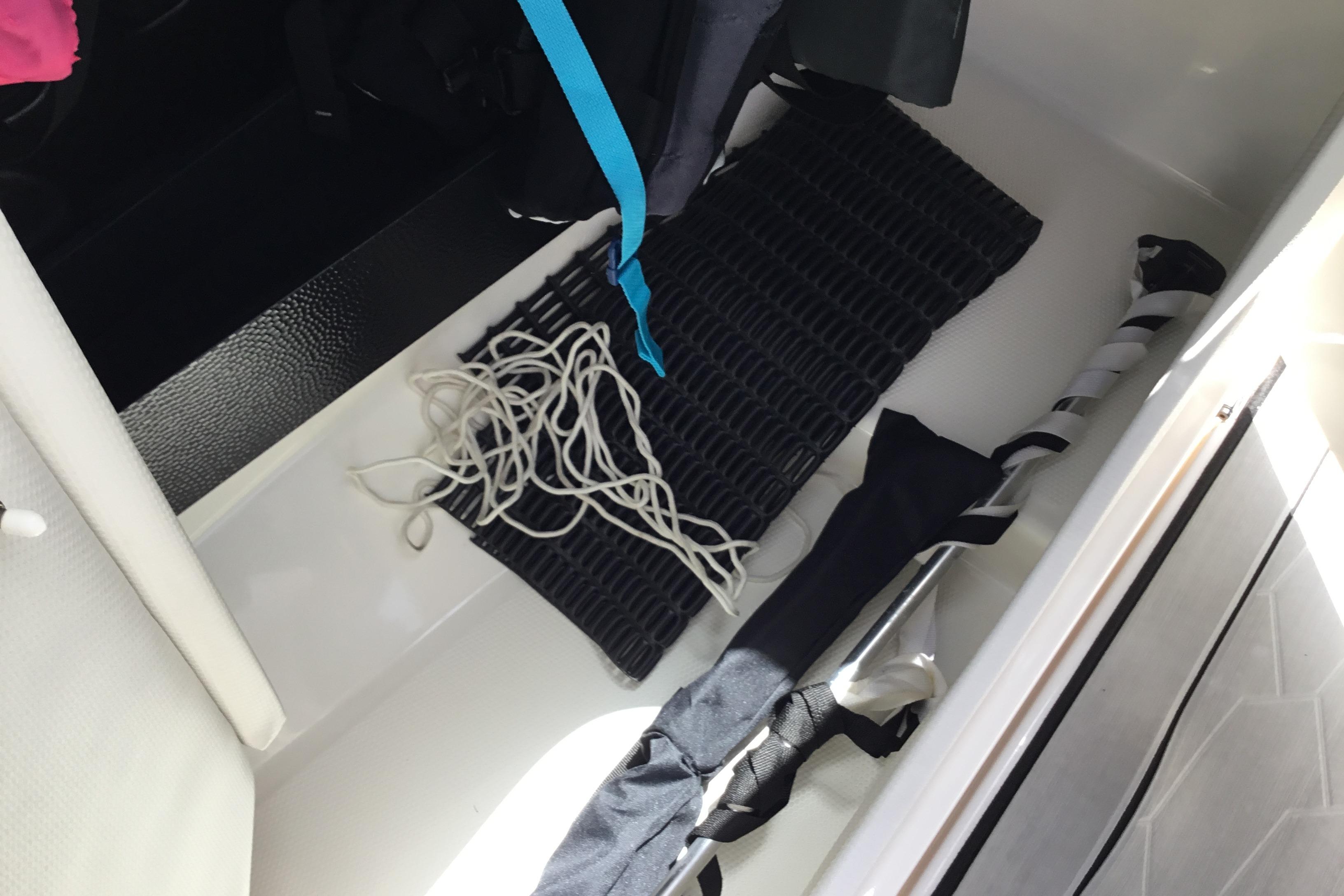 Storage compartment of 2023 Yamaha Boats 252XE with rope and equipment.