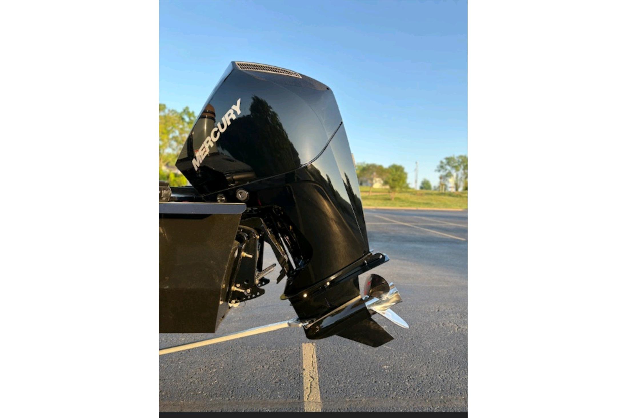 Outboard motor on a 2026 Regency 230 DL boat, parked outdoors.