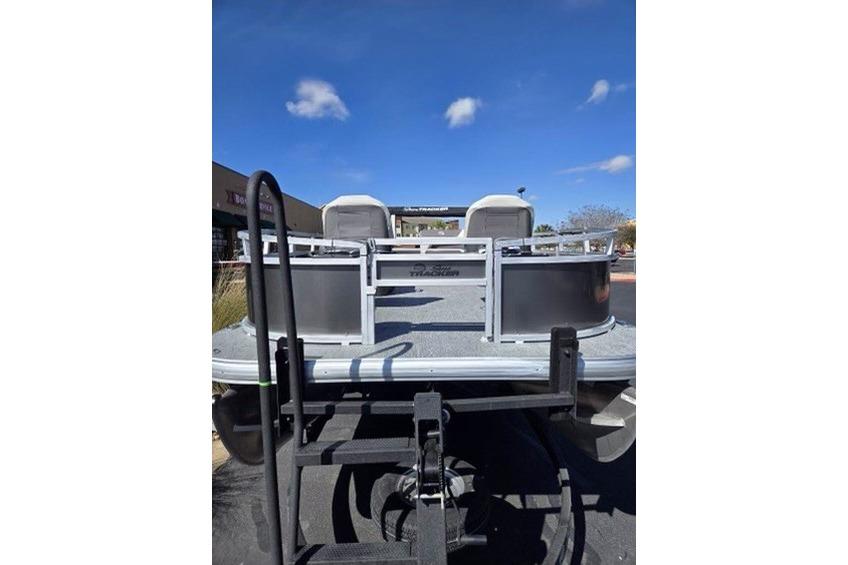 2026 Sun Tracker Bass Buggy 16 XL Select pontoon boat, rear view under clear blue sky.
