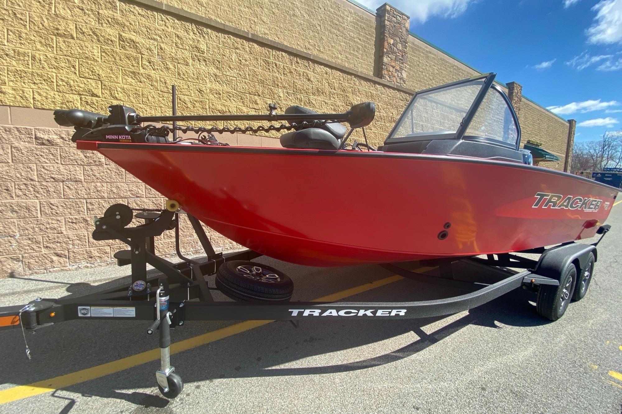 2026 Tracker Targa V-18 WT boat in vibrant red on a trailer, parked outdoors.