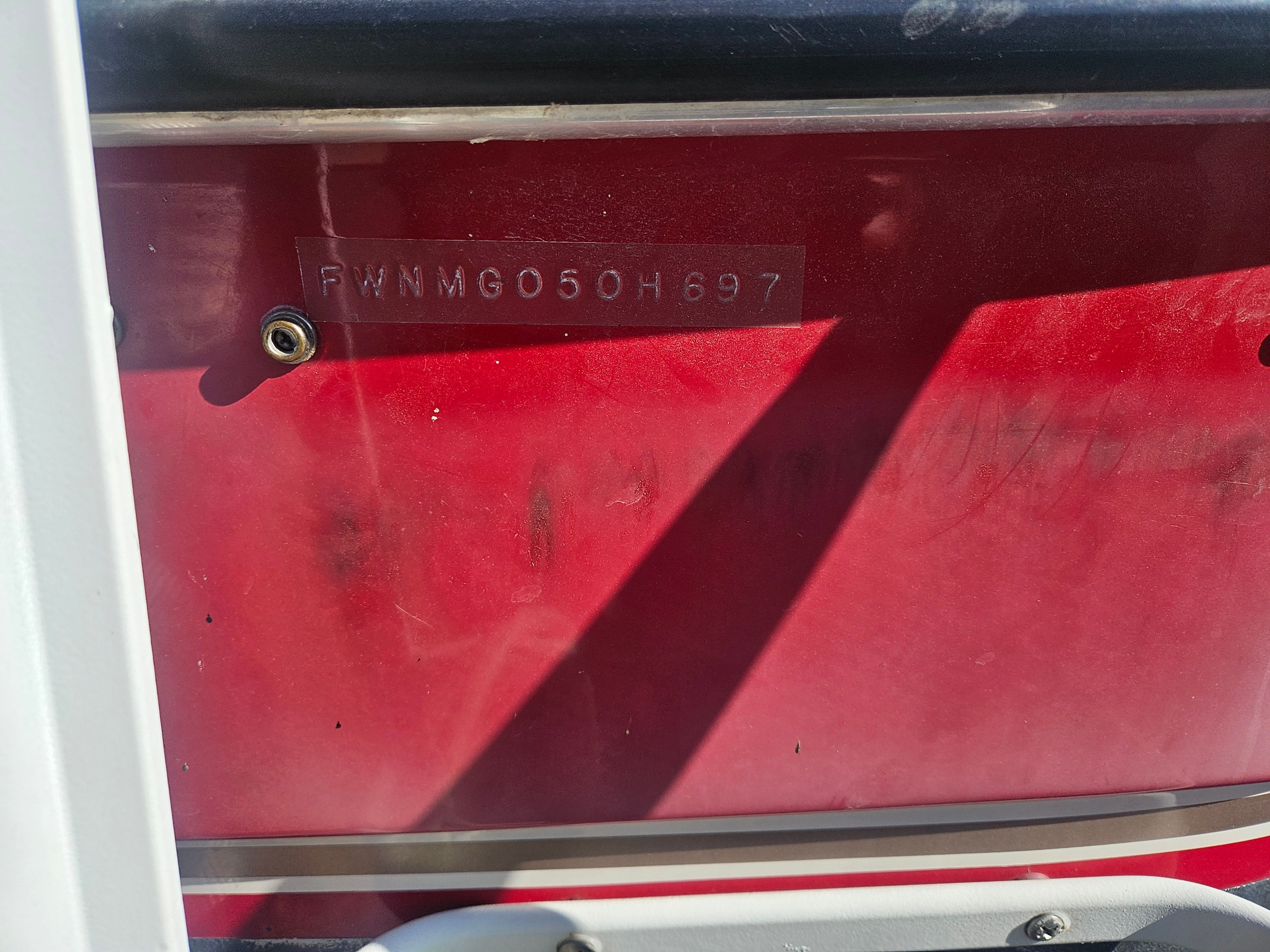 Close-up of a red boat hull with a serial number.