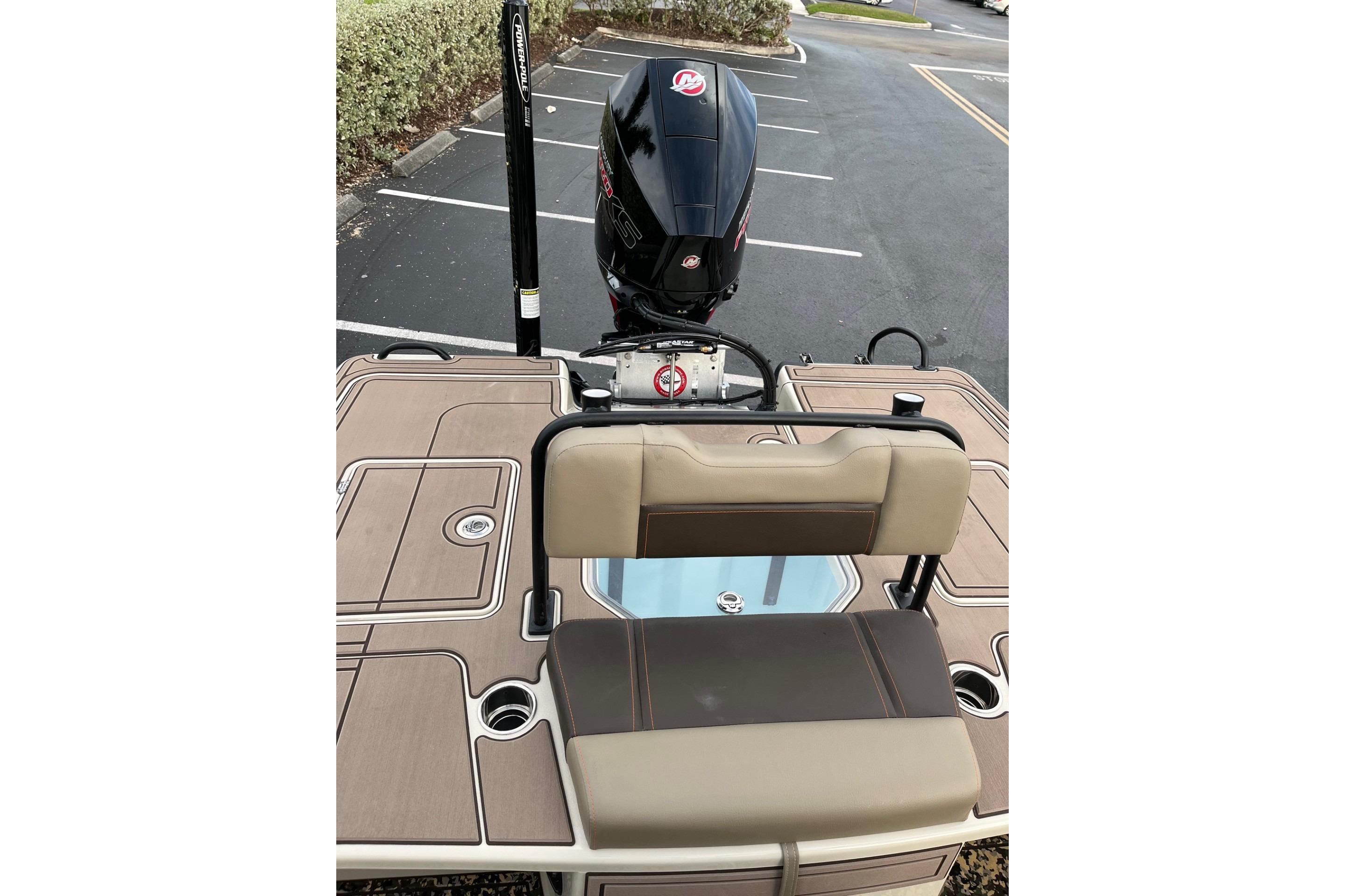 2026 Mako 18 Pro Skiff Backwater Edition boat with seating and motor in parking lot.