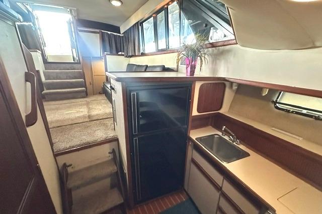 Interior of 1989 Carver 32 Aft Cabin Motor Yacht with kitchenette and seating area.