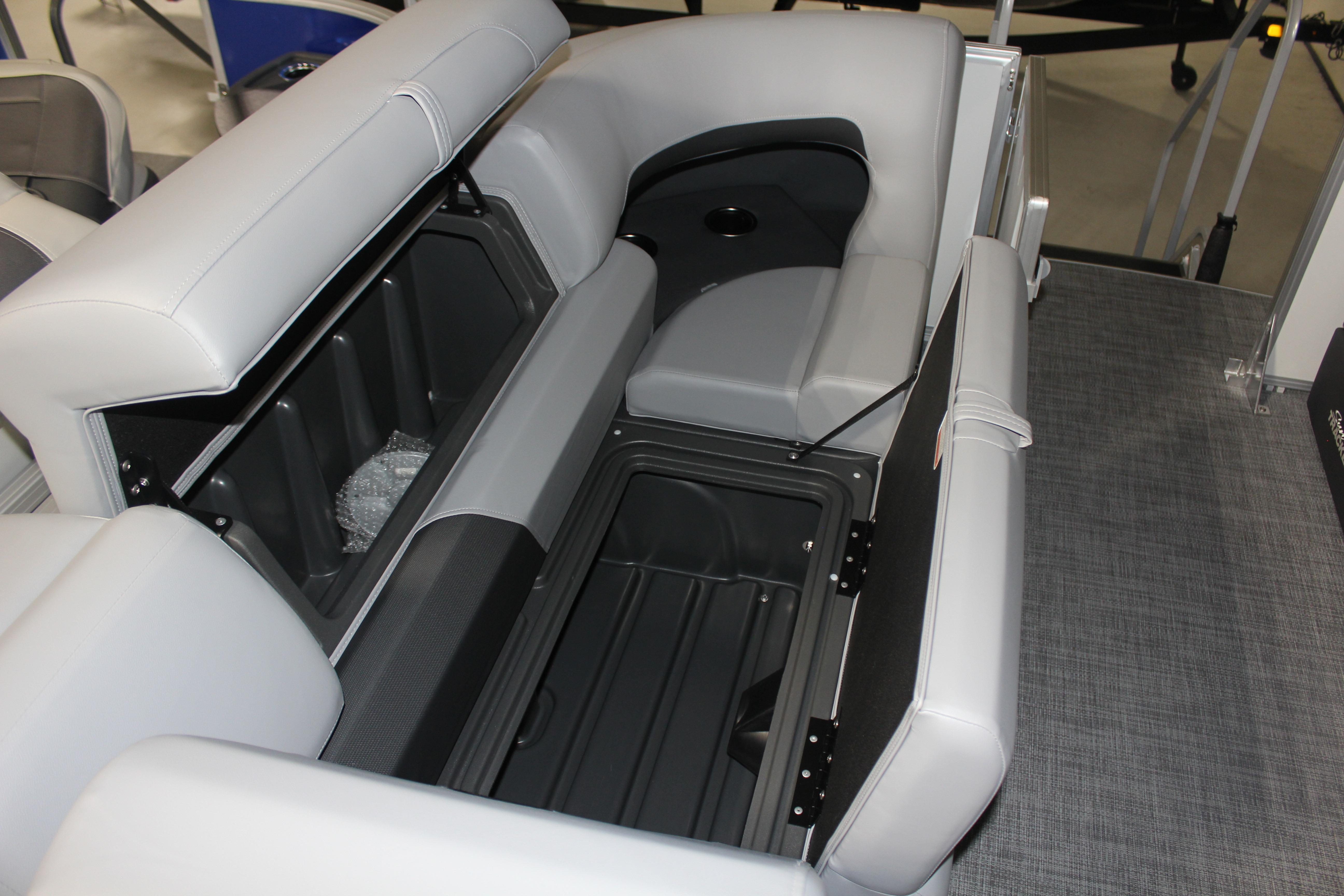 2026 Sun Tracker Party Barge 22 DLX interior seating with storage compartments open.