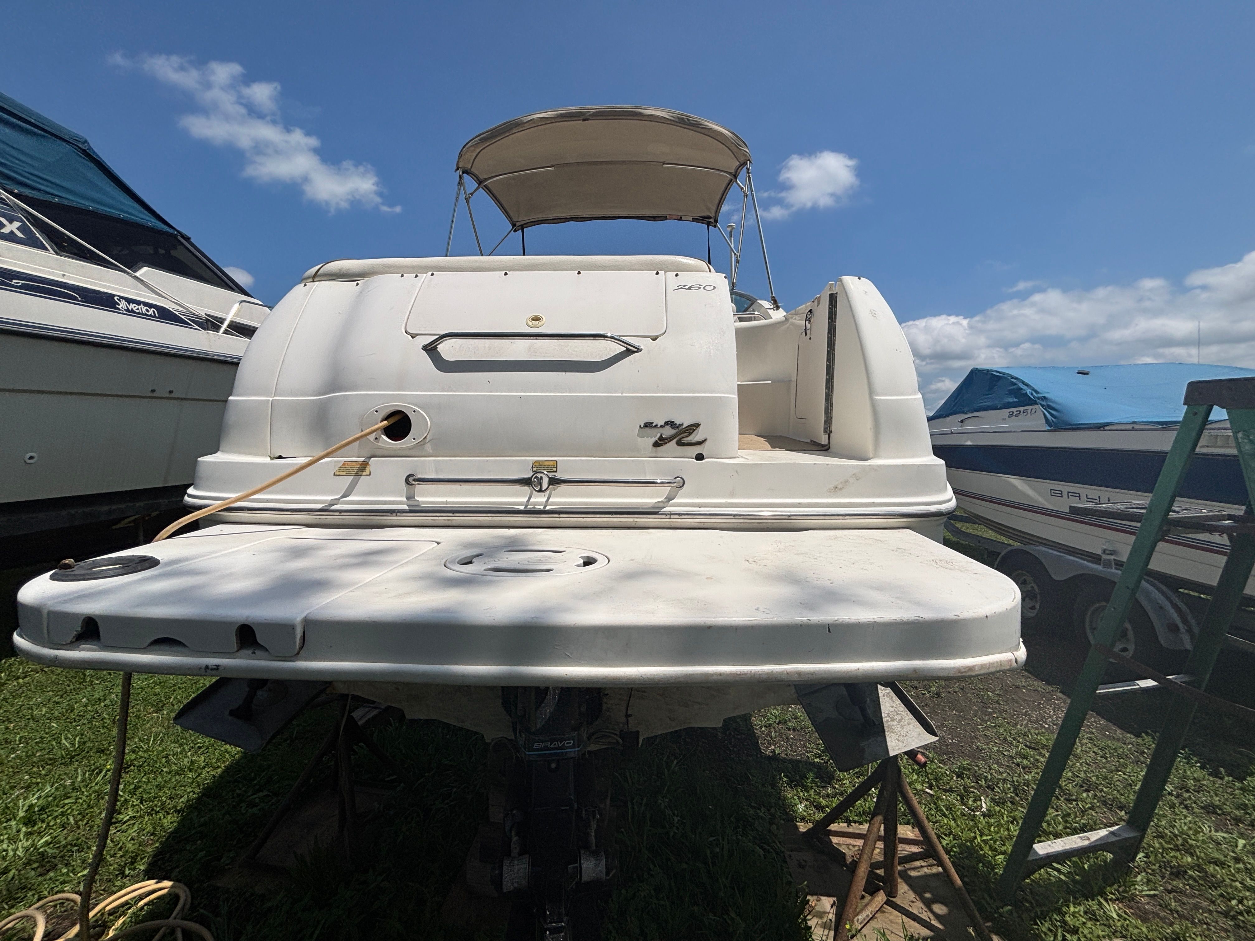 A 2000 Sea Ray Sundancer 260 on grass. It features a sunshade.