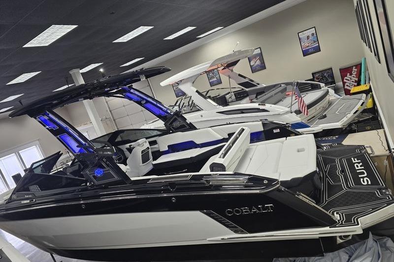2026 Cobalt R8 Surf boat in showroom, sleek design with illuminated features.