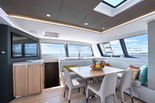 Luxurious interior of 2025 Privilege Signature 580 yacht with modern dining area and panoramic windows.