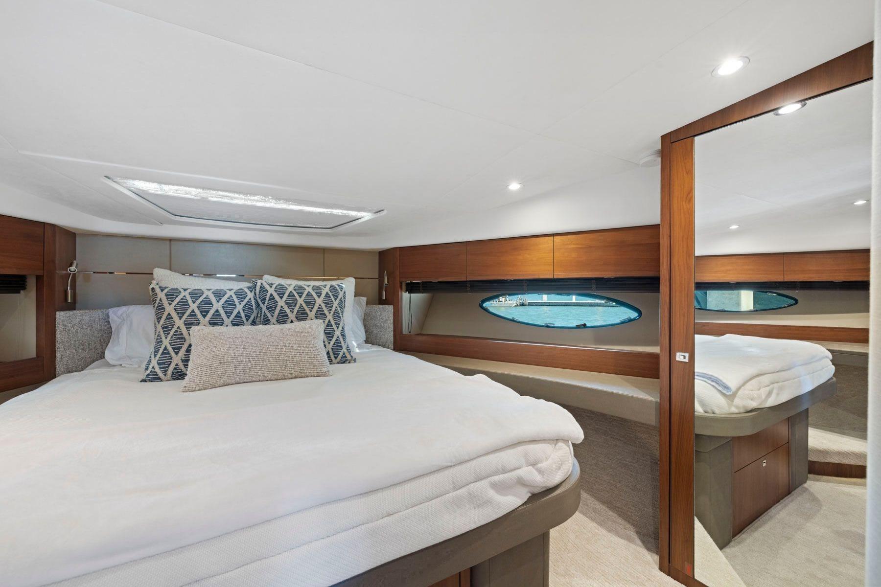 Luxurious bedroom interior of 2015 Princess 60 Flybridge Motor Yacht with elegant bedding.