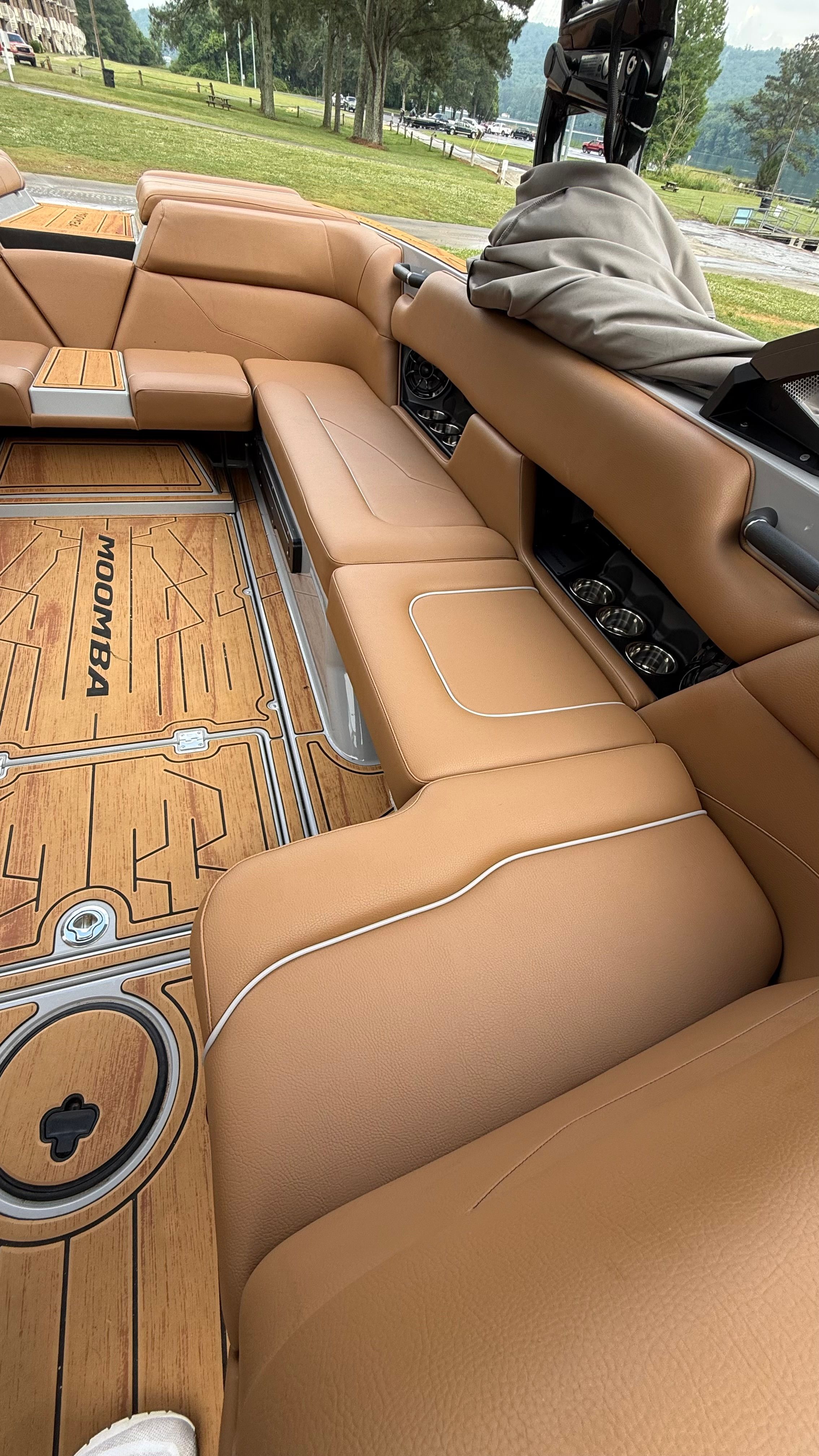 Interior of a 2025 Malibu Mojo with brown leather seats and wooden flooring.
