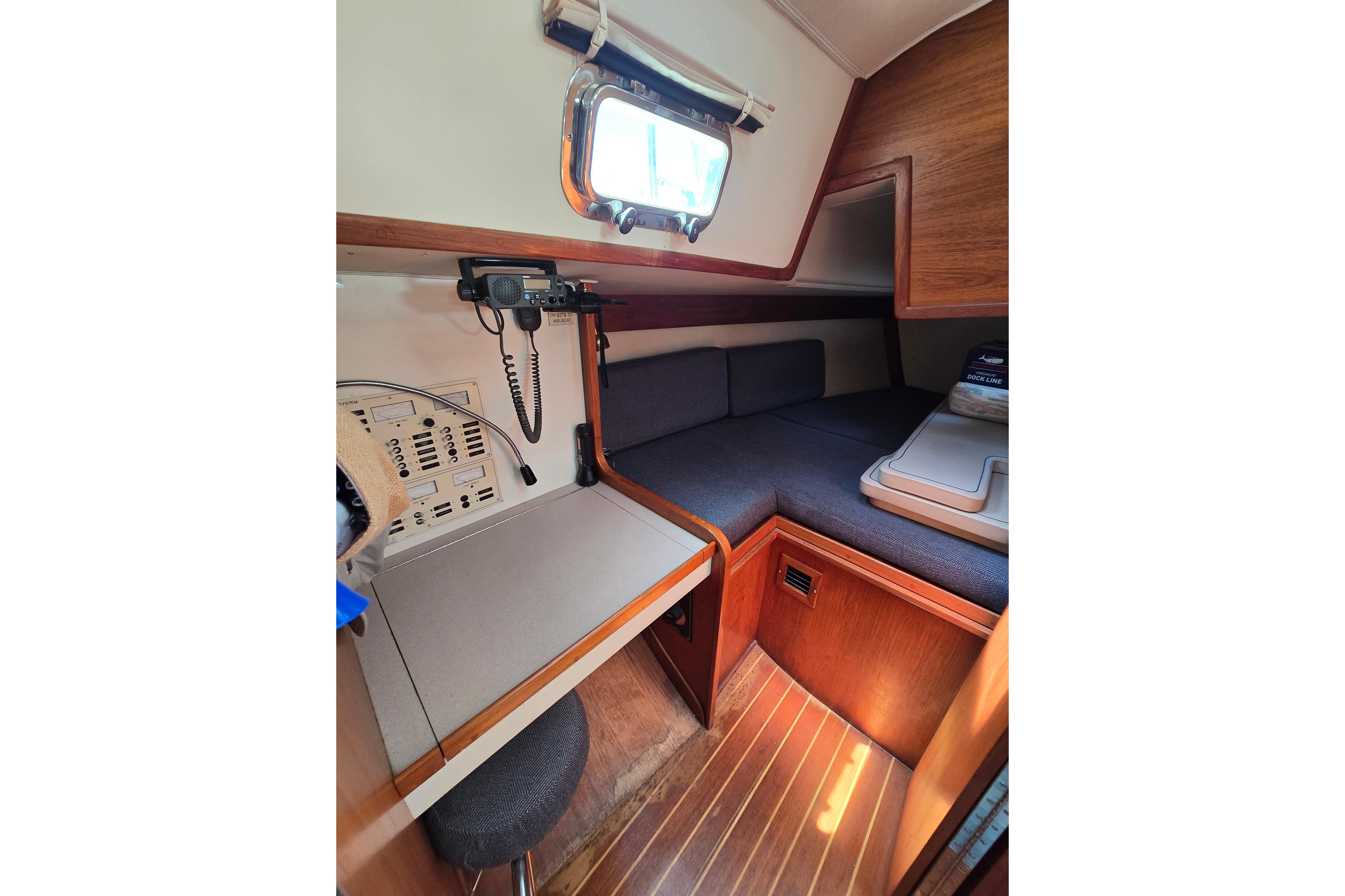 Interior of a 1993 Caliber 35 sailboat with navigation station and cozy sleeping area.