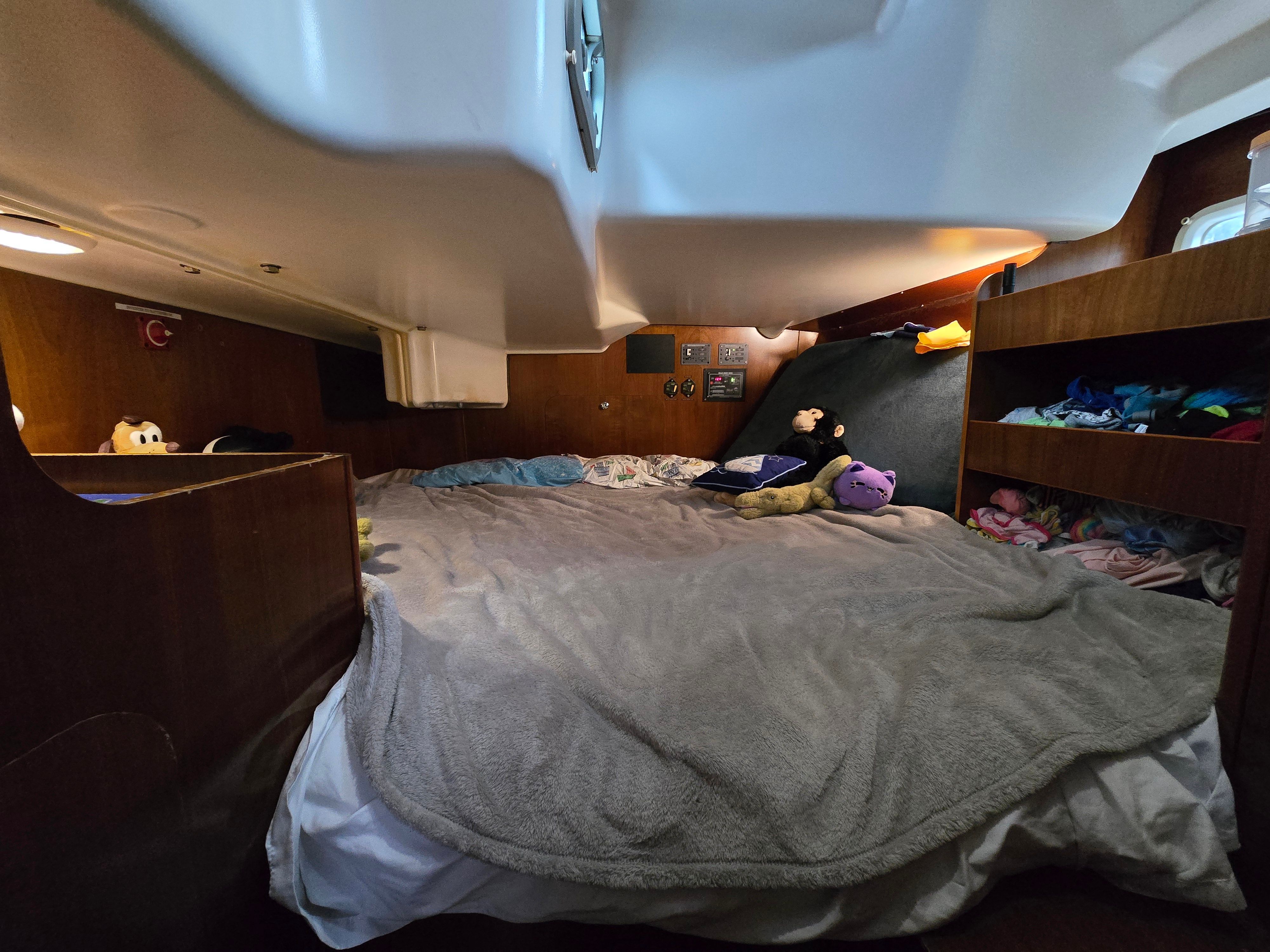 Interior of a 1998 Beneteau 411 with a cozy bed and wood paneling.